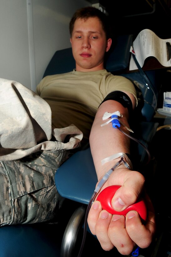 U.S. Air Force Airman 1st Class Alex Durbin, 633rd Air Base Wing photojournalist, provides pressure while giving blood during a blood drive at Langley Air Force Base, Va., June 12, 2012. The Armed forces blood program has 19 centers around the country dedicated to Department of Defense personnel. (U.S. Air Force photo by Staff Sgt. Ashley Hawkins/Released)
