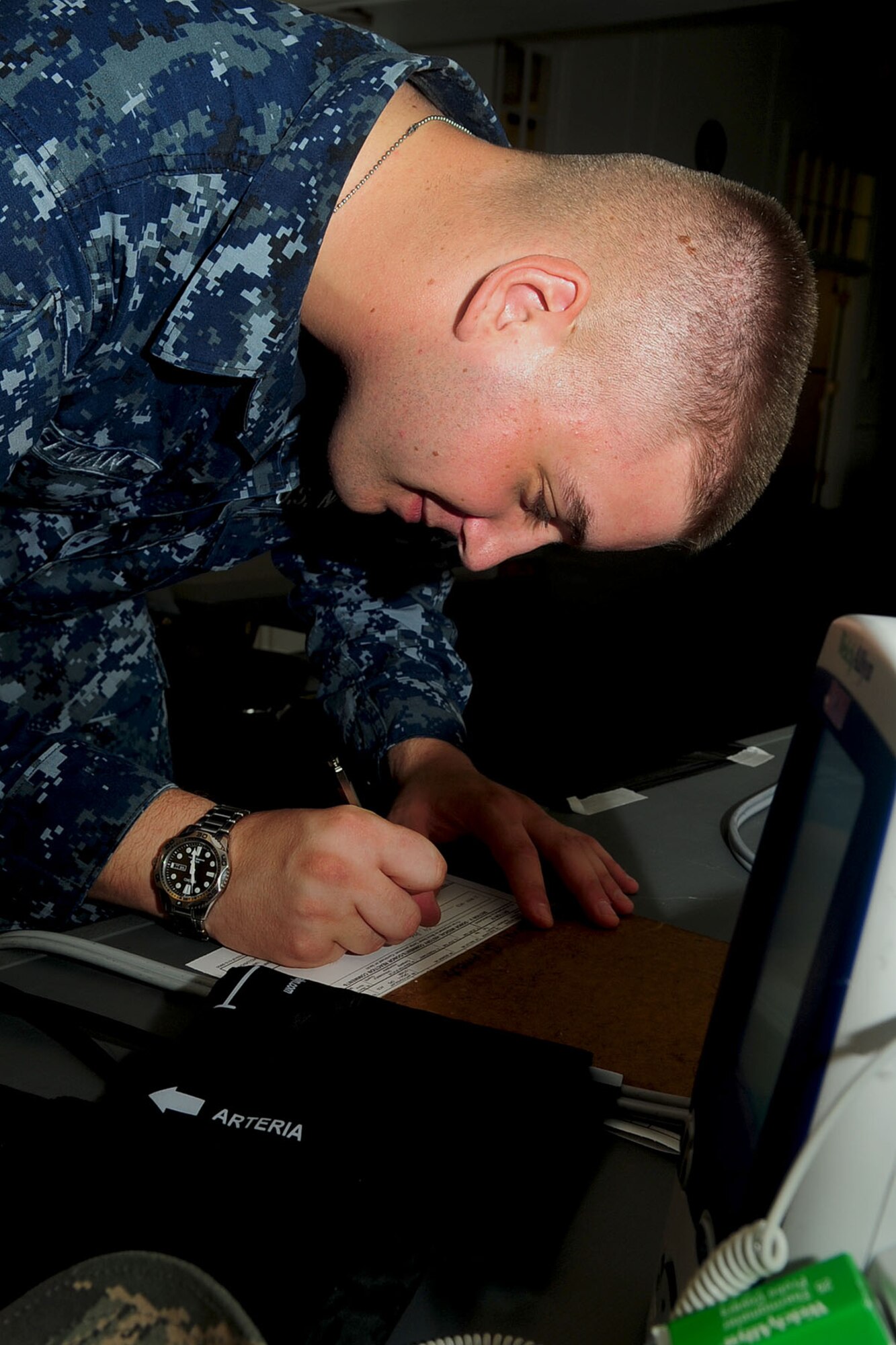 U.S. Navy Seaman Calvin Koffman, Portsmouth Naval Center hospitalman, writes down a patient's information during a blood drive at Langley Air Force Base, Va., June 12, 2012. Half of the donated blood is sent to various deployed locations, while the other half is provided for military hospitals state-side. (U.S. Air Force photo by Staff Sgt. Ashley Hawkins/Released)