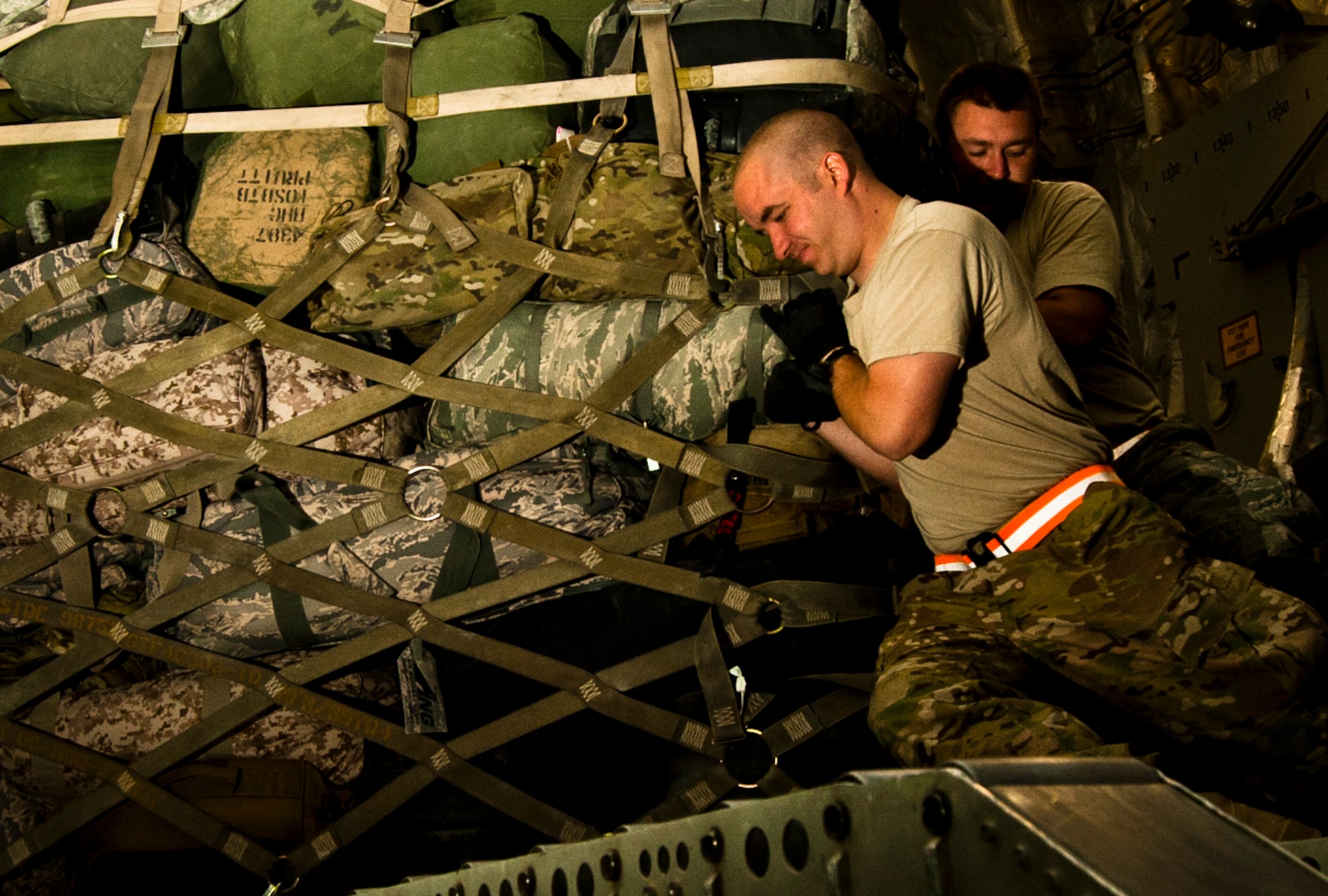 Senior Airman Robert Taylor (front), 455th Expeditionary Aerial Port Squadron Passenger Services representative and Tech. Sgt Nicholas Hotham (back), 455th Expeditionary Passenger Services Line supervisor, maneuver a cargo pallet aboard U.S. Air C-17 Globemaster III at Bagram Airfield, Afghanistan, June 7, 2012. Airmen with 455 EAPS serve up to 2,500 passengers daily. (U.S. Air Force photo/Capt. Raymond Geoffroy)