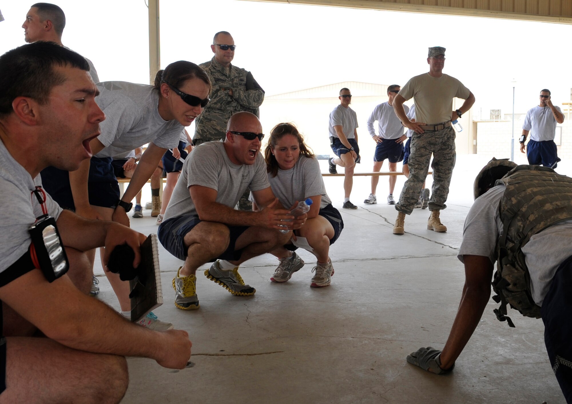 SOUTHWEST ASIA – Several observers motivate their squadron during the buddy push-ups at the Defender’s Challenge between the 386th and 387th Expeditionary Security Forces Squadrons here June 9, 2012. Seven four-person participated in the challenge. The 386th took home the trophy. (U.S. Air Force photo/Staff Sgt. Alexandra M. Boutte)