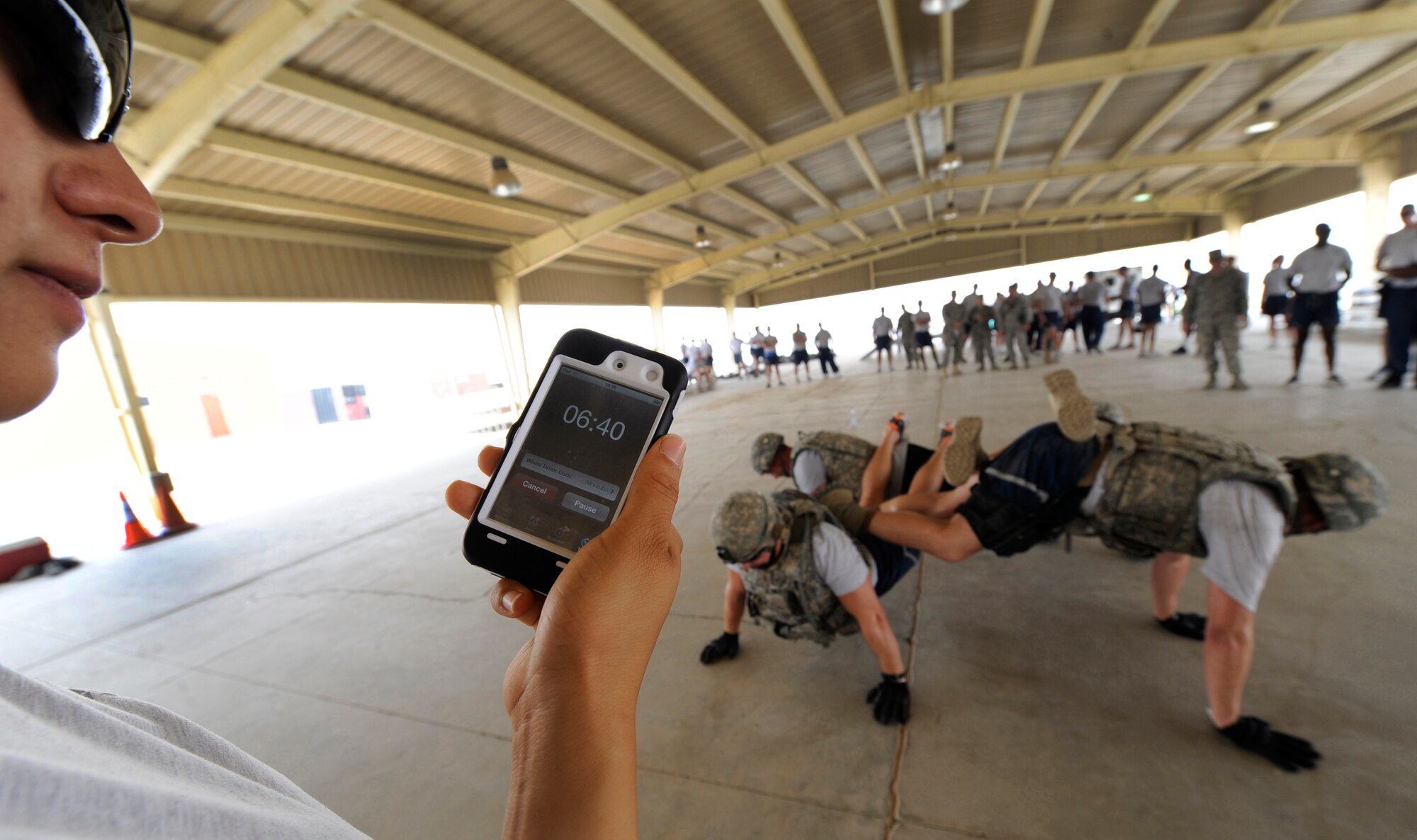 SOUTHWEST ASIA – A volunteer cadre from the 386th Expeditionary Security Forces Squadron times a 386th ESFS fire team at the first Defender Challenge here June 9, 2012. Each team had 10 minutes to do as many four-person buddy push-ups as they could. This team pushed out 65. (U.S. Air Force photo/Staff Sgt. Alexandra M. Boutte) 