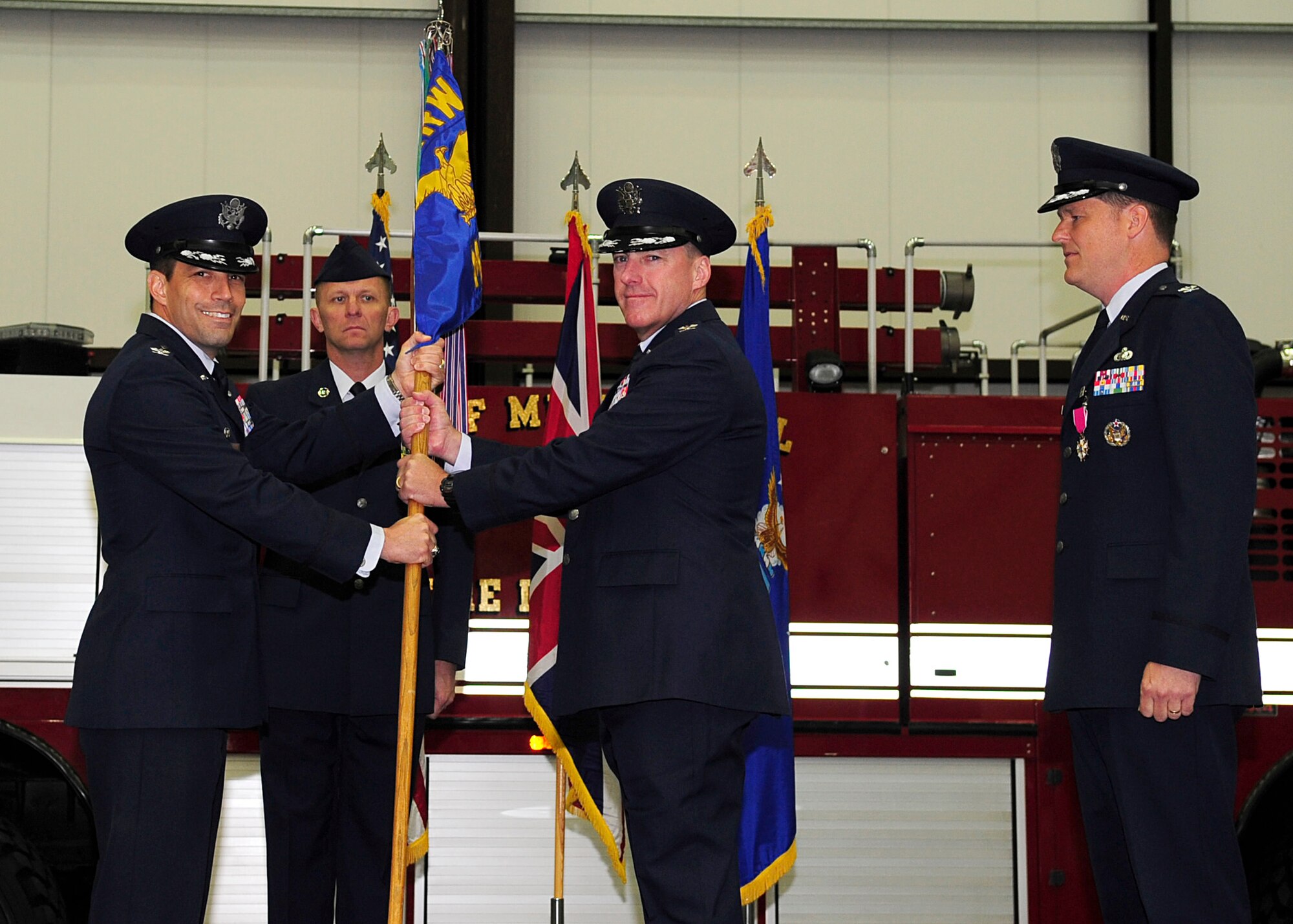 RAF MILDENHALL, England – Col. Daniel Merry, (right) 100th Mission Support Group commander, accepts  the 100th MSG’s guidon from Col. Christopher Kulas, (left) 100th Air Refueling Wing commander, during the 100th MSG change of command here June 13, 2012. Merry receives the guidon to symbolize his accepting command of the 100th MSG. (U.S. Air Force photo/Senior Airman Ethan Morgan)