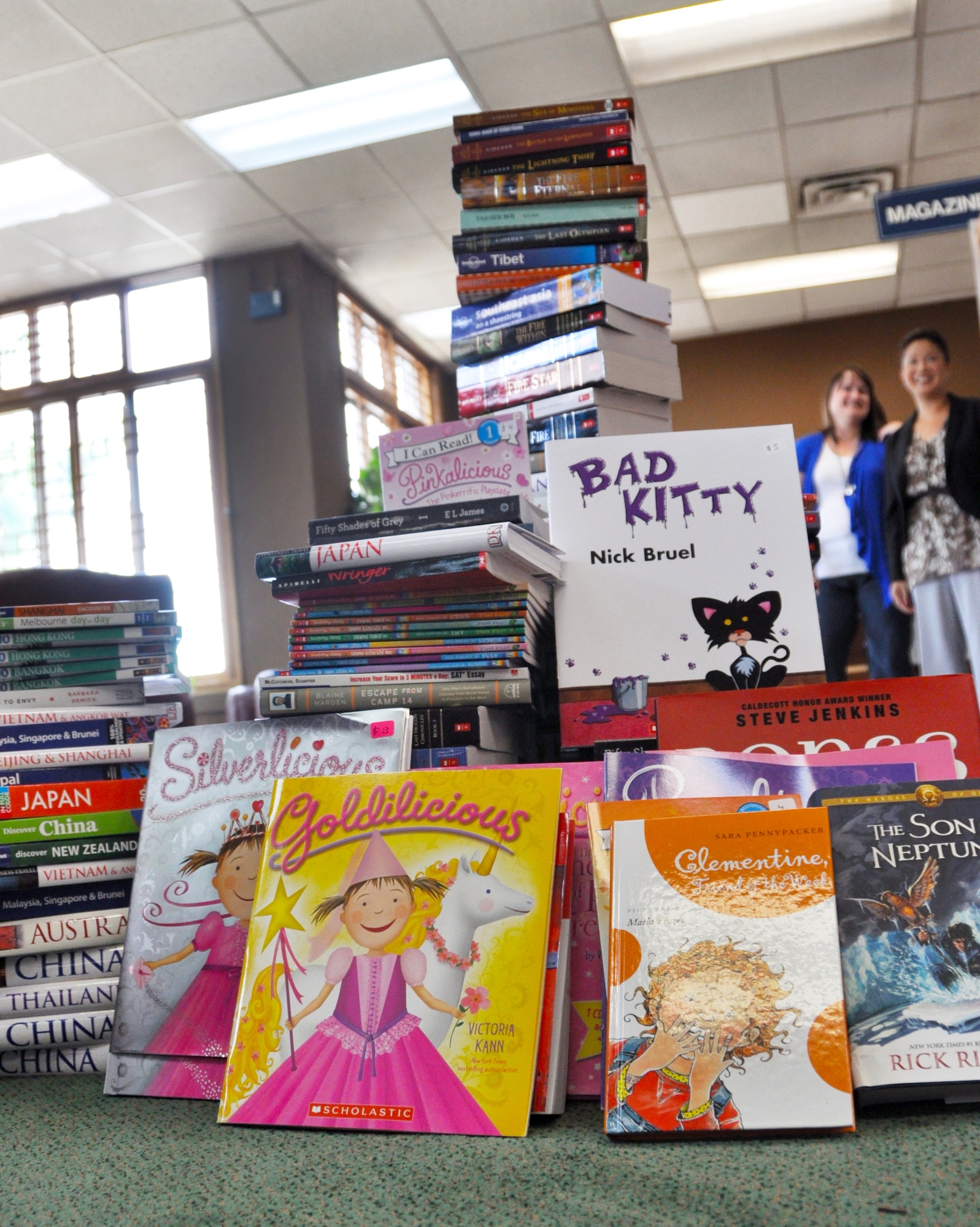 Members from the Osan Officers’ Spouses Club donate more than $2,000 worth of books to the Osan Library June 14, 2012. A majority of the 400 travel, children’s, region specific, and adult education books were purchased online and from the Osan American Elementary School book fair with funds raised through charitable fundraisers like Wild Wild West night. From left to right: Nigel York, Osan Spouses Club president, Chris Corbin and Opps Lawson, Wild Wild West night co-chairs. (U.S. Air Force photo/Staff Sgt. Stefanie Torres)