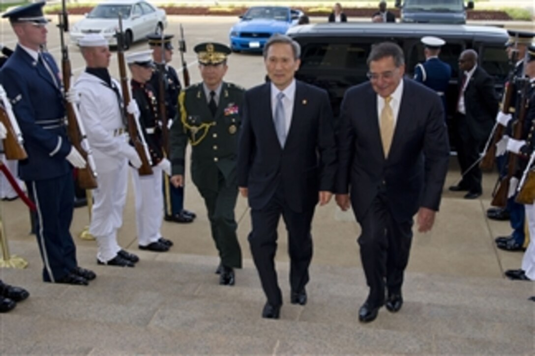 Secretary of Defense Leon E. Panetta escorts South Korea's Minister of National Defense Kim Kwan-jin through an honor cordon and into the Pentagon on June 13, 2012.  