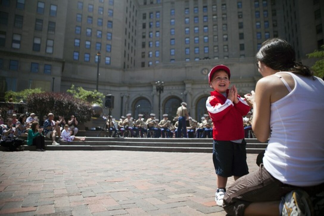 CLEVELANDâ??Samuel Heiser, 3, cheers the Marine Corps Base Quantico Band along with his mother, Rachel, here in Public Square, June 14, 2012. Public Square is one of the sites of displays available for public during the Marine Week Cleveland. Marine Week brings Marine Corps vehicles, aircraft and equipment for public viewing at venues such as Public Square, Voinovich Park, Gateway Plaza and Rock and Roll Hall of Fame. Marine Week Cleveland celebrates community, country and the Corps. More than 750 Marines journeyed to Cleveland for the event. Ohio has more than 9,000 active and reserve Marines, making it one of the top-five producers of Marines. The culminating  event for the week is the Marine Air-Ground Task Force demo, June 16-17, in which Marines will invade the Burke Lakefront Airport by land, air, and sea. (U.S. Marine Corps Photo by Cpl. Marcin Platek)::r::::n::