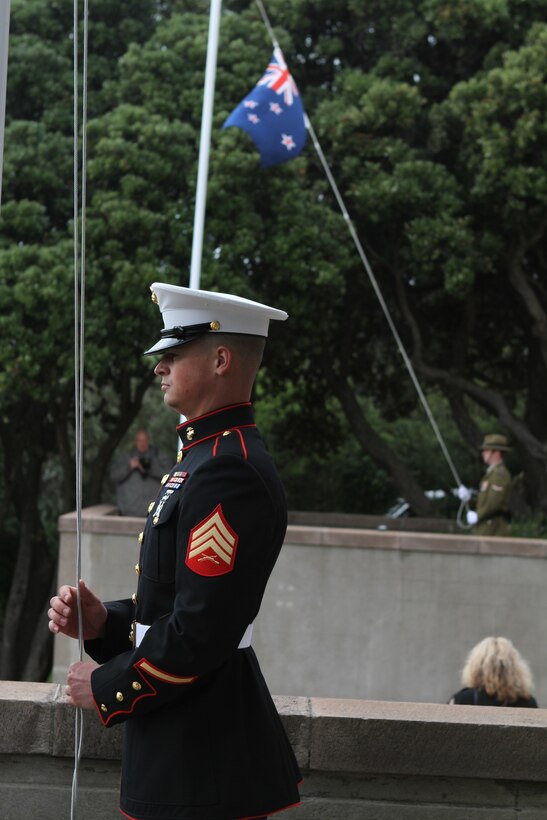 Sergeant Aaron A. Bouquet, a fire direction controlman with Alpha Battery, 1st Battalion, 11th Marine Regiment, lowers the U.S. colors in timing with the New Zealand colors during a commemoration ceremony at the National War Memorial, here, June 14. Bouquet, a 23-year-old native of Comanche, Texas, also stood guard at the foot of the memorial. Prominent government and military officials of the United States and New Zealand commemorated the 70th anniversary of the arrival of U.S. forces in Wellington during World War II. Australian and New Zealand forces were conducting heavy fighting in Northern Africa in 1942 while U.S. forces played a significant role in the defense of Oceania.::r::::n::(U.S. Marine Corps photo by Sgt. Jacob H. Harrer)::r::::n::