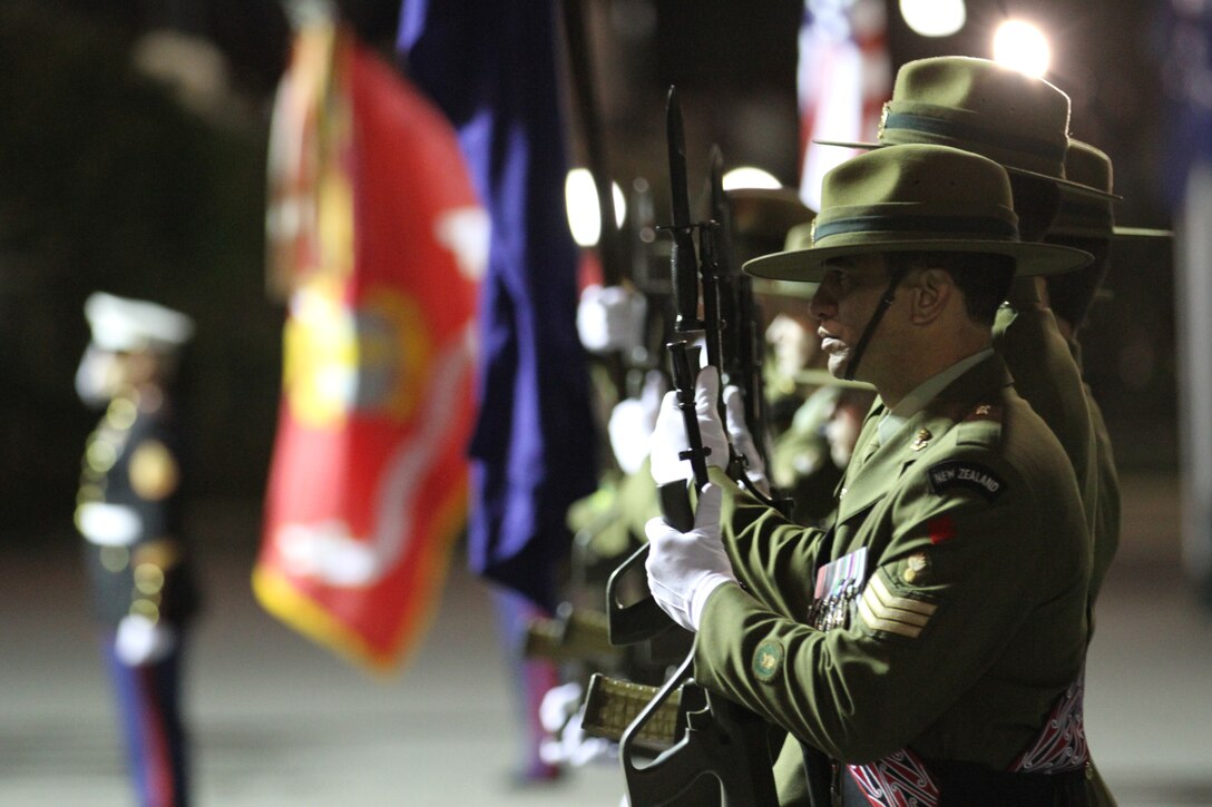 WELLINGTON, New Zealand – New Zealand Army Sgt. Awanui Melbourne, a carpenter with the 2nd Engineer Regiment, conducts present arms during the sunset ceremony with U.S. Marines at the Parliament House here, June 14. Government and military officials of the United States and New Zealand commemorated the 70th anniversary of the arrival of U.S. forces in Wellington during World War II. Australian and New Zealand forces were conducting heavy fighting in Northern Africa in 1942 while U.S. forces played a significant role in the defense of Oceania.::r::::n::(U.S. Marine Corps photo by Sgt. Jacob H. Harrer)::r::::n::