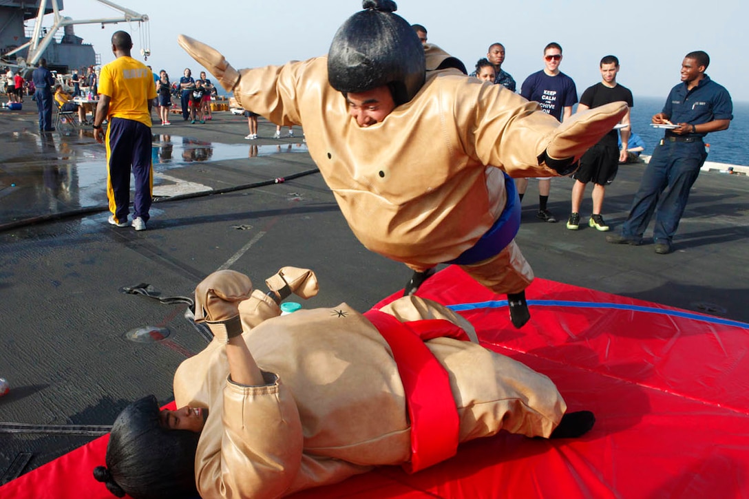 Lance Cpl. Joshua Phillips, top, and Cpl. Zamar Aguon, Marine Fighter Attack Squadron 251 ordnance technicians, participate in a sumo-suit bout during a steel beach picnic aboard aircraft carrier USS Enterprise, June 15. The carrier is currently deployed to support maritime operations in the U.S. 5th Fleet area of responsibility.