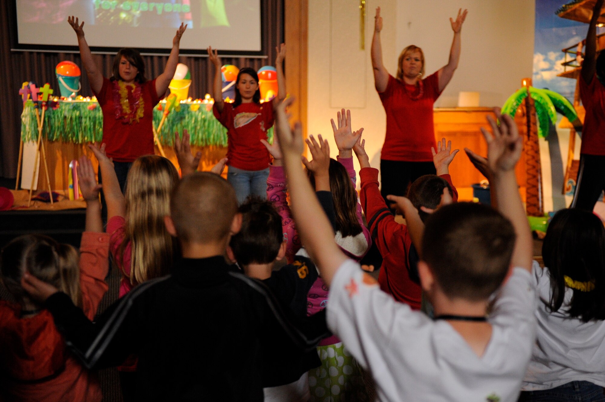 VANDENBERG AIR FORCE BASE, Calif. -- Volunteers and children sing and dance at Vacation Bible School hosted by the 30th Space Wing Chapel staff here Friday, June 15, 2012. The school is in their tenth year of operation, teaching 140 students in five different classes with the help of more than 50 base volunteers. (U.S. Air Force photo/Staff Sgt. Levi Riendeau)