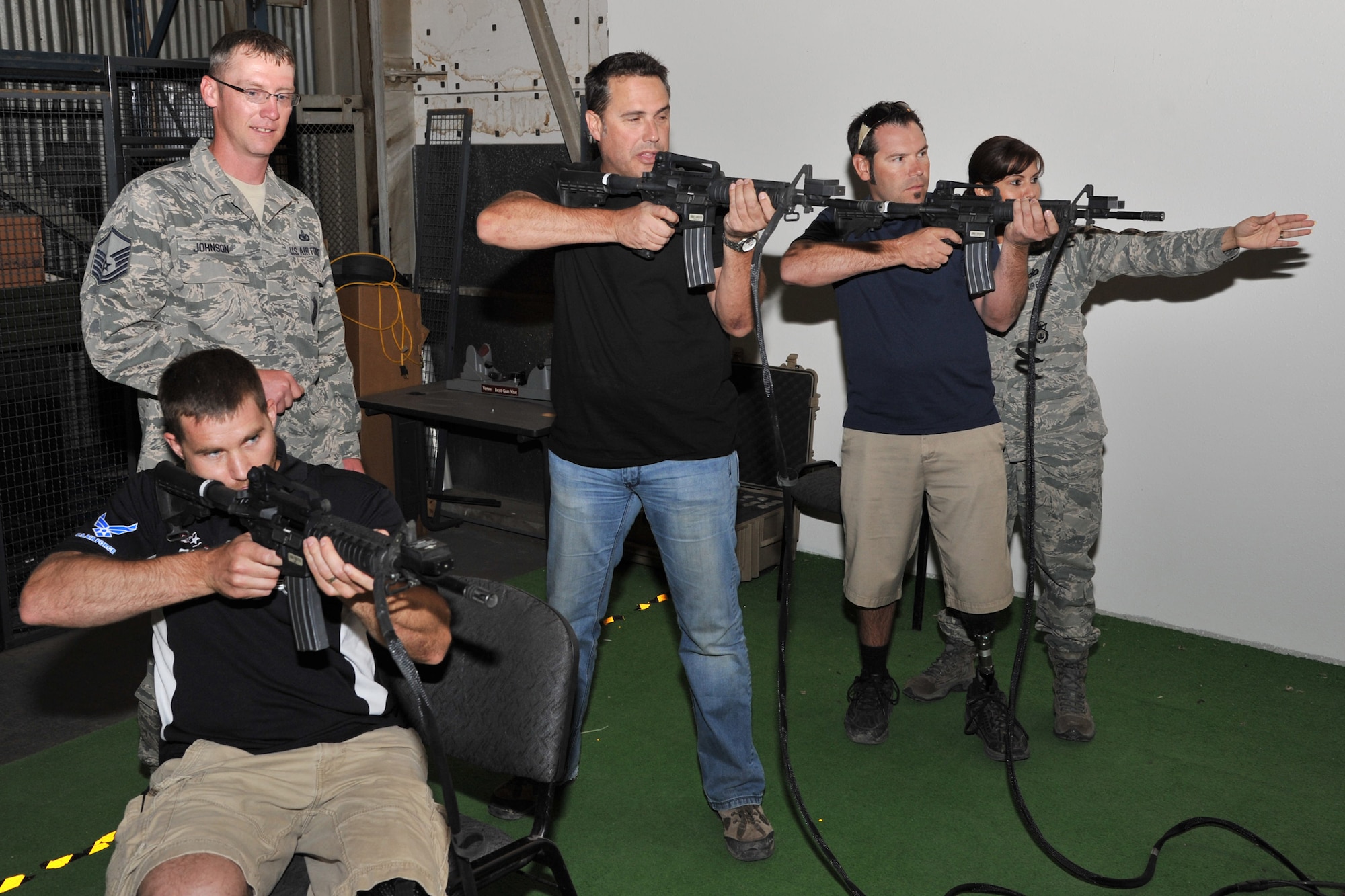Master Sgt. Eric Johnson, resouces and training NCO in charge, and Staff Sgt. Mariana Rosado, security forces training instructor, both with the 341st Security Support Squadron, teach American300 Baja 100 Tour participants how to use the firing equipment they train with at the EST 2000 June 13. Tour members from left to right are Mike Schultz, Paul Thomas and Chris Ridgeway. (U.S. Air Force photo/John Turner)