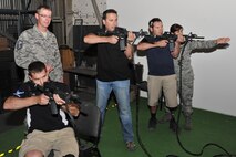Master Sgt. Eric Johnson, resouces and training NCO in charge, and Staff Sgt. Mariana Rosado, security forces training instructor, both with the 341st Security Support Squadron, teach American300 Baja 100 Tour participants how to use the firing equipment they train with at the EST 2000 June 13. Tour members from left to right are Mike Schultz, Paul Thomas and Chris Ridgeway. (U.S. Air Force photo/John Turner)