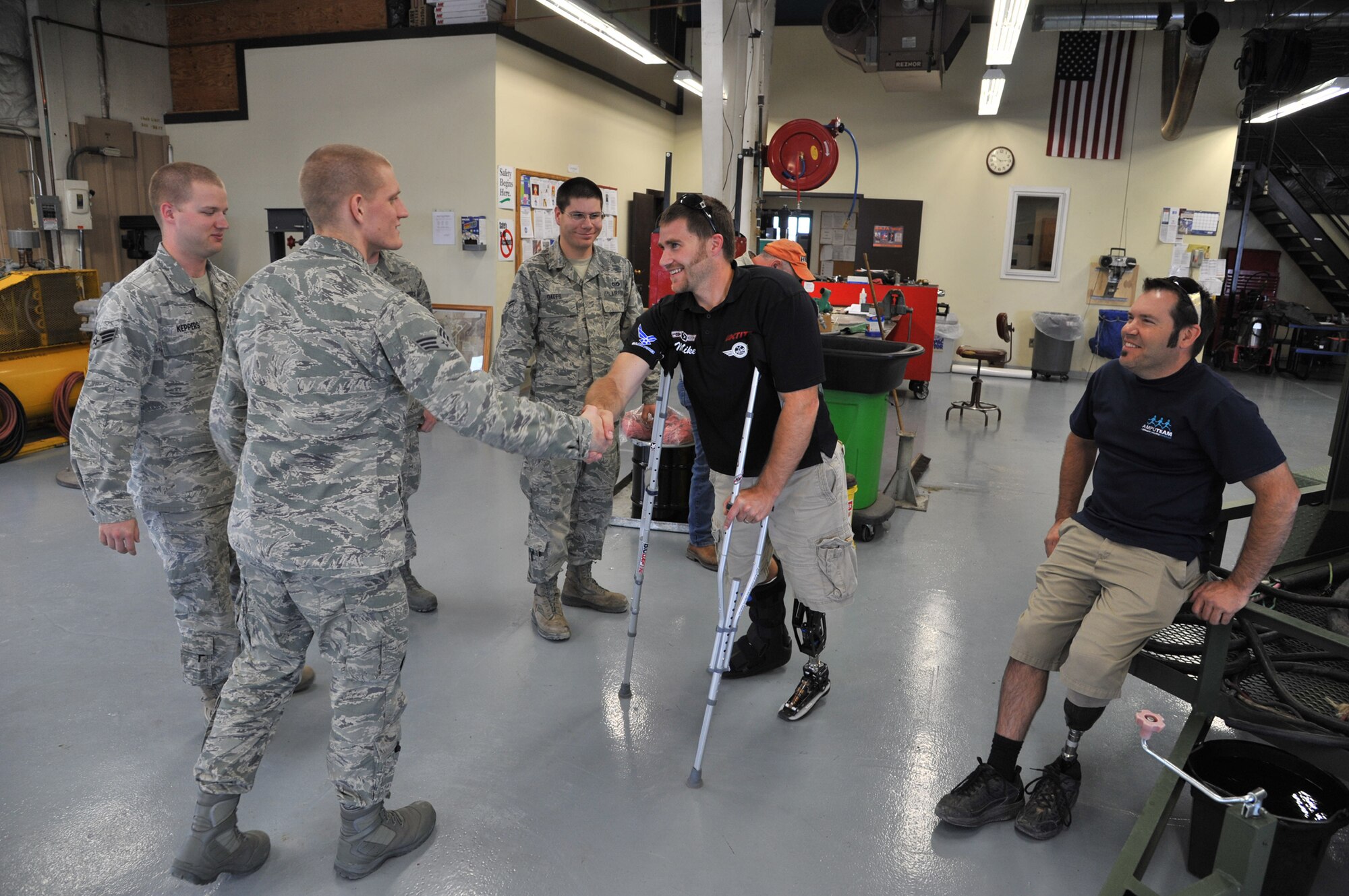 Mike Schultz, Amercian300 Baja 1000 Tour participant, shakes hands with Airmen from the 341st Civil Engineer Squadron's power pro shop as his fellow athlete Chris Ridgeway looks on. The two were part of a five-person group that visited Malmstrom June 12-14. (U.S. Air Force photo/John Turner)