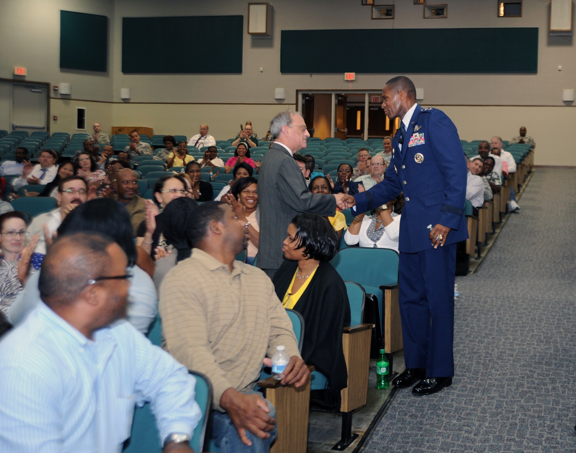Air Force District of Washington Commander Maj. Gen. Darren W. McDew coins James Scowden, material management branch chief, June 15 during a commander's call on Joint Base Andrews, Md. Scowden will soon retire after 43 years of active duty and civil service. (U.S. Air Force photo by Airman 1st Class Tabitha N. Haynes)
