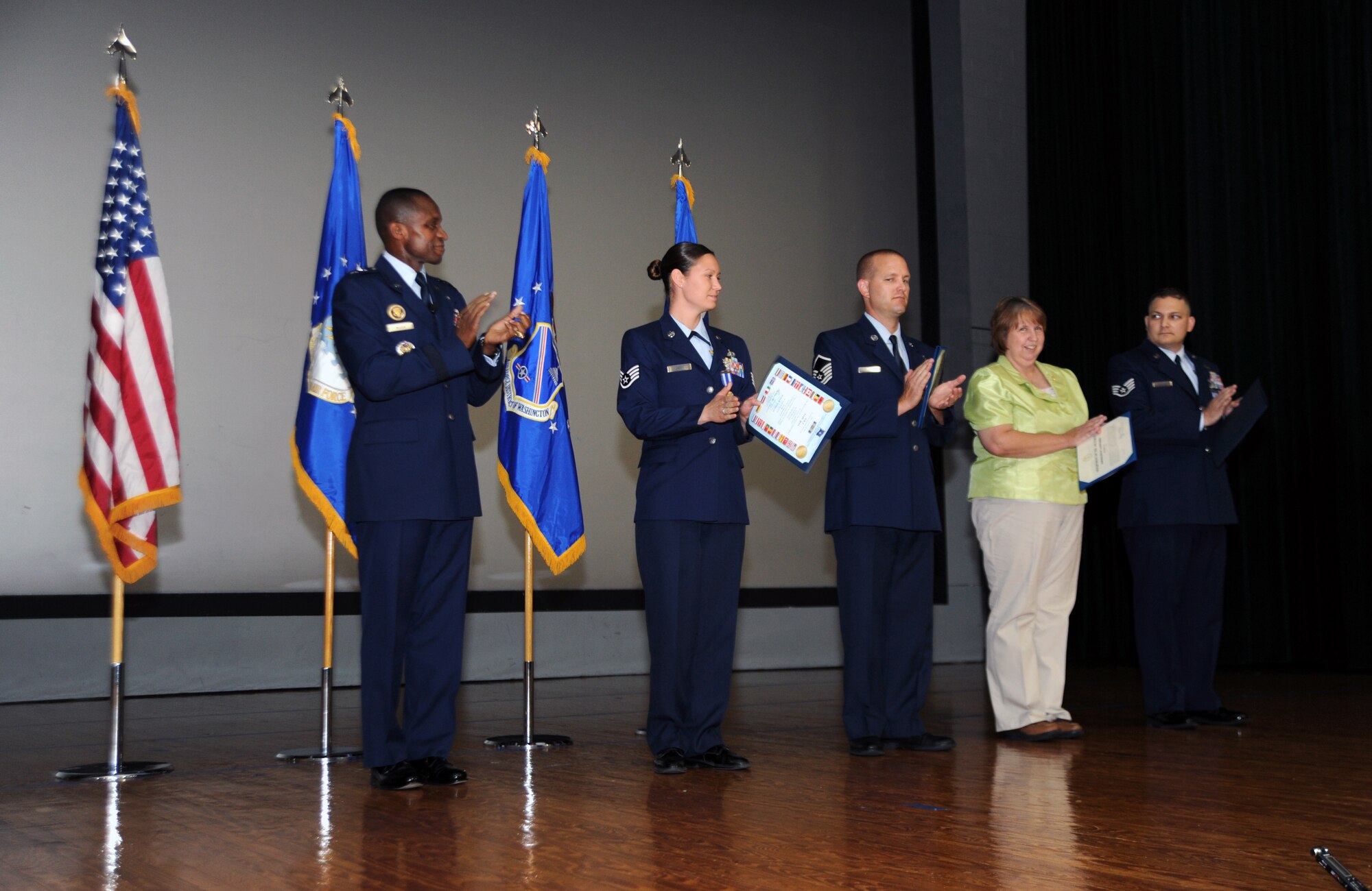 Air Force District of Washington Commander Maj. Gen. Darren W. McDew recognizes award winners during the commander's call June 15 on Joint Base Andrews, Md. Those recognized included (from left to right) Staff Sgt. Nicole Green, protocol NCO, Master Sgt. Cameron Rogers, 1st Helicopter Squadron maintainer, Valerie Lewis, commander’s action group speech writer, and Staff Sgt. Jeremy Boggs, contracting manager. (U.S. Air Force photo by Airman 1st Class Tabitha N. Haynes)