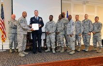 Chief Master Sgt. Jeffery Wilson, 20th Maintenance Group quality assurance superintendent, receives a certificate of appreciation from Chief Master Sgt. of the Air Force James Roy, presented by Chief Master Sgt. James Wilkerson, 20th Fighter Wing command chief, and chiefs from the 20th Fighter Wing during his retirement ceremony at the Carolina Skies Club and Conference Center, Shaw Air Force Base, S.C., June 15, 2012. Wilson retired after serving for twenty years in aircraft maintenance. (U.S. Air Force photo by Senior Airman Amber E. N. Jacobs/Released)