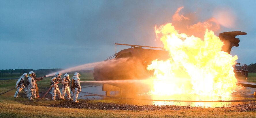 Firefighters from the 436th Civil Engineer Squadron extinguish a simulated airplane fire June 12, 2012 at Dover Air Force Base, Del. The members of the fire protection flight regularly train for real world emergencies.  (U.S. Air Force photo by Adrian R. Rowan)