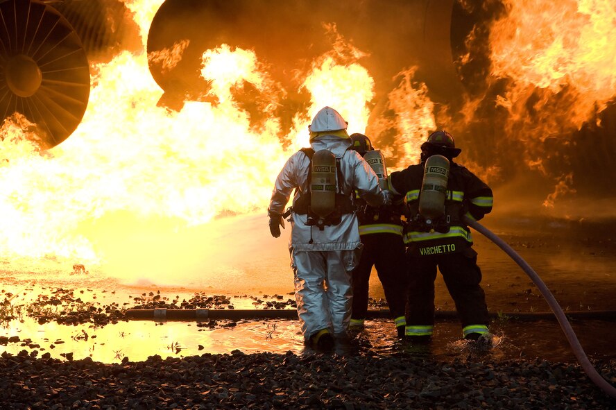 Firefighters from the 436th Civil Engineer Squadron extinguish a simulated airplane fire June 12, 2012 at Dover Air Force Base, Del. The members of the fire protection flight regularly train for real world emergencies.  (U.S. Air Force photo by Adrian R. Rowan)
