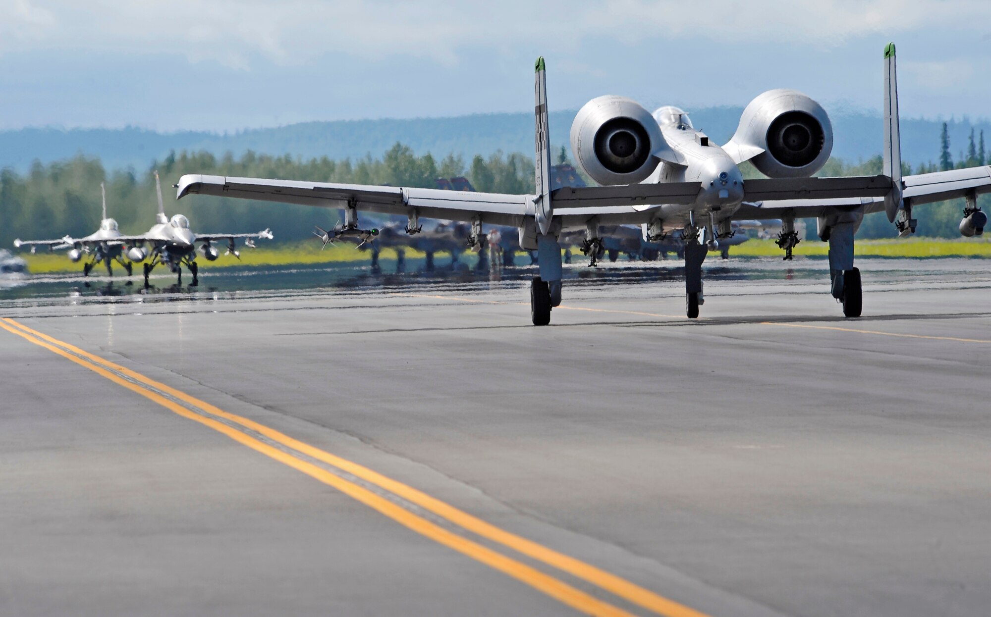 An A-10 Thunderbolt II taxis the runway towards two F-16C Fighting Falcons as aircraft recover from a morning mission during RED FLAG-Alaska 12-2 June 11, 2012, Eielson Air Force Base, Alaska.  RF-A, a two -week-long exercise, focuses on aerial combat training for U.S. and allied forces and is conducted within the Joint Pacific Alaska Range Complex, a 67,000 square-mile training range.  The A-10 Thunderbolt II is assigned to the 25 Fighter Squadron, Osan Air Base, Republic of Korea.  (U.S. Air Force photo/Staff Sgt. Miguel Lara III)