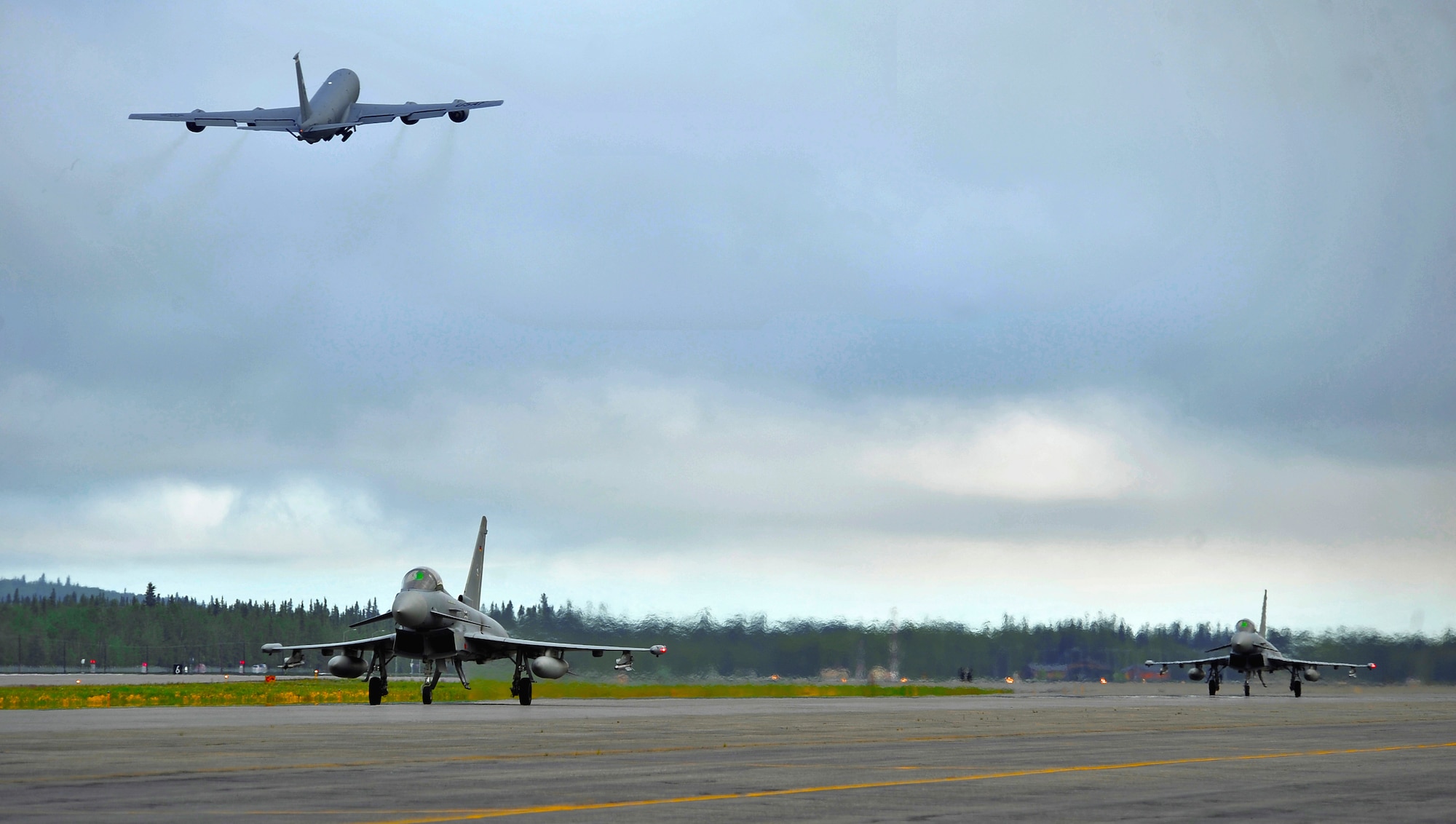 Two German air force Eurofighter Typhoons taxi the runway as a KC-135R Stratotanker launches from the runway during RED FLAG-Alaska 12-2 June 11, 2012, Eielson Air Force Base, Alaska.  This is the first time the Typhoon has participated in RF-A.  The KC-135R Stratotanker is assigned to the 22nd Air Refueling Wing, McConnell Air Force Base, Kan.  (U.S. Air Force photo/Staff Sgt. Miguel Lara III)