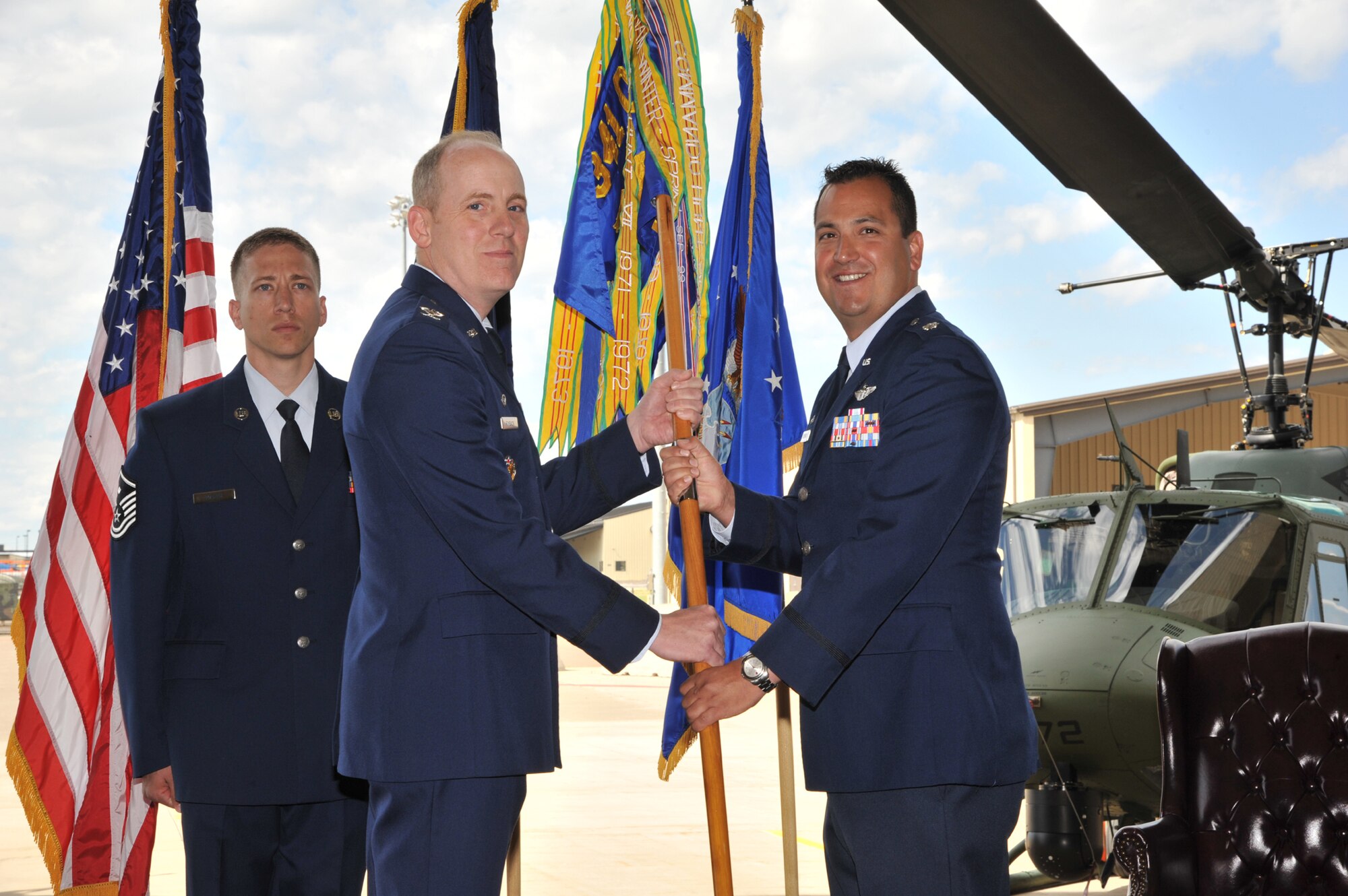 Lt. Col. Mathew Contreras, right, accepts command of the 40th Helicopter Squadron from Col. Edward Rimback, 341st Operations Group commander, June 8 in the helicopter maintenance hangar.  Master Sgt. Jeremiah Martin, 341st OG first sergeant, looks on.  (U.S. Air Force photo/John Turner) 