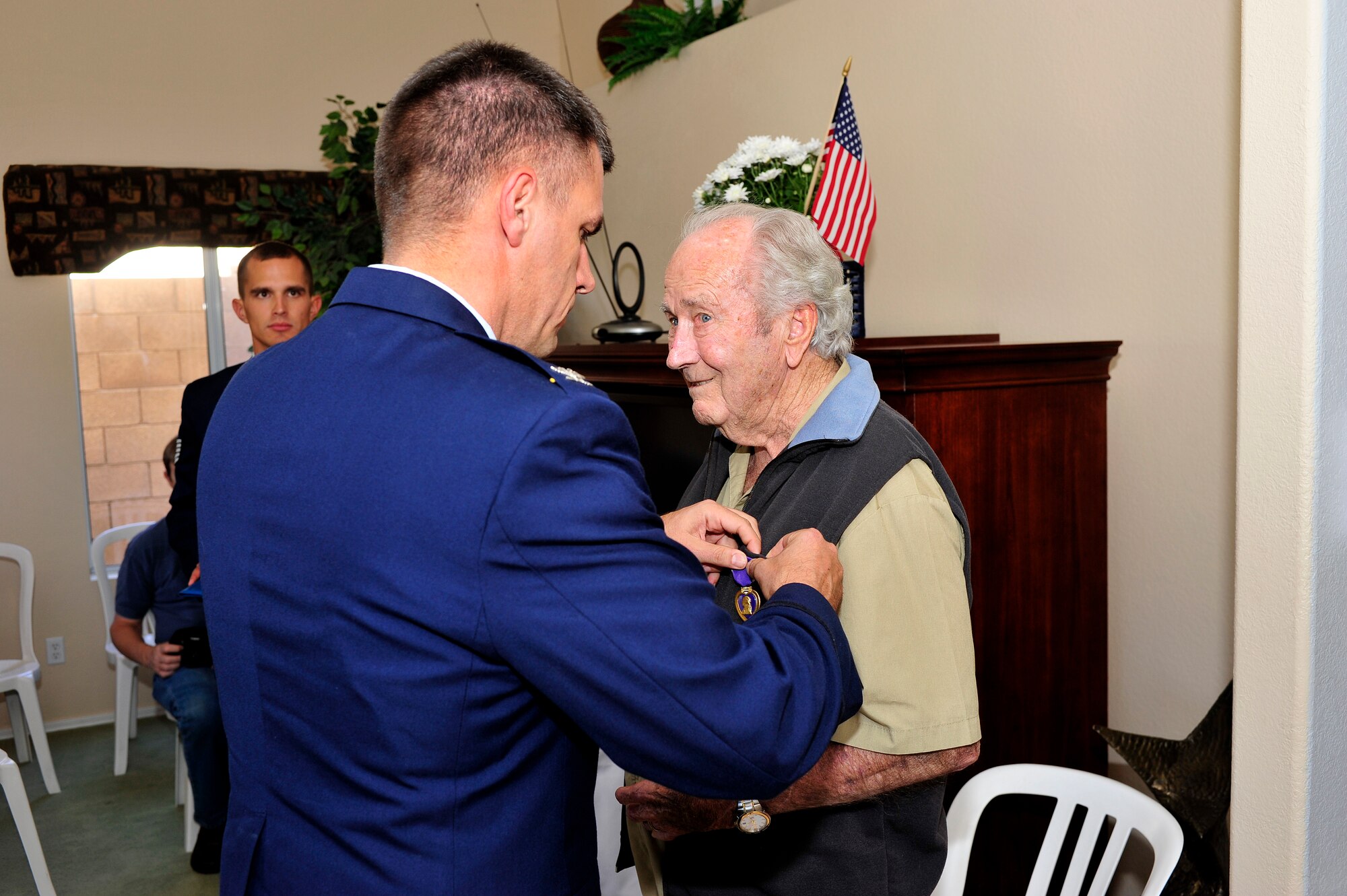 Col. Robert Webb, 56th Fighter Wing vice commander, presents a Purple Heart medal to Carlyle Gardner at his home in Mesa, Ariz., June 13, 2012. Gardner was a B-17G Flying Fortress flight engineer and gunner during World War II. His aircraft was attacked and crash landed in Belgium, where he was captured by German soldiers and spent just under a year as a prisoner of war.  (U.S. Air Force photo by Staff Sergeant Jason Colbert)