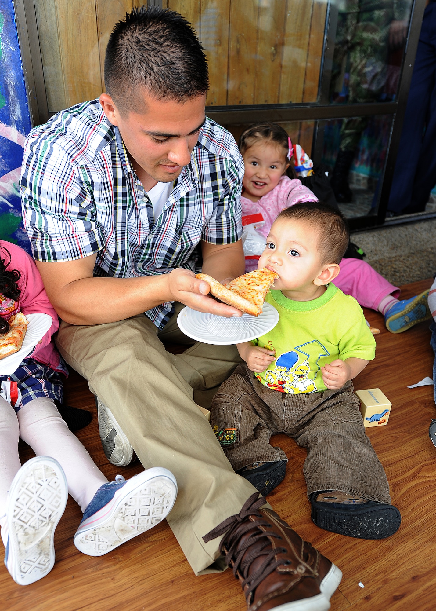 Staff Sgt. Peter Salinas, 571st Mobility Support Advisory Squadron air advisor, feeds pizza to one of the children from the Asociación Amigos del Niño Ayudame, Bogota, Colombia June 9 as part of an Air Mobility Command Building Partner Capacity month-long mission.  Members of the Colombian air force, Inter-American Air Forces Academy and 12th Air Force (Air Forces Southern) also participated in the visit and donated toys, clothes and books to the children.  (U.S. Air Force photo by Tech. Sgt. Lesley Waters)