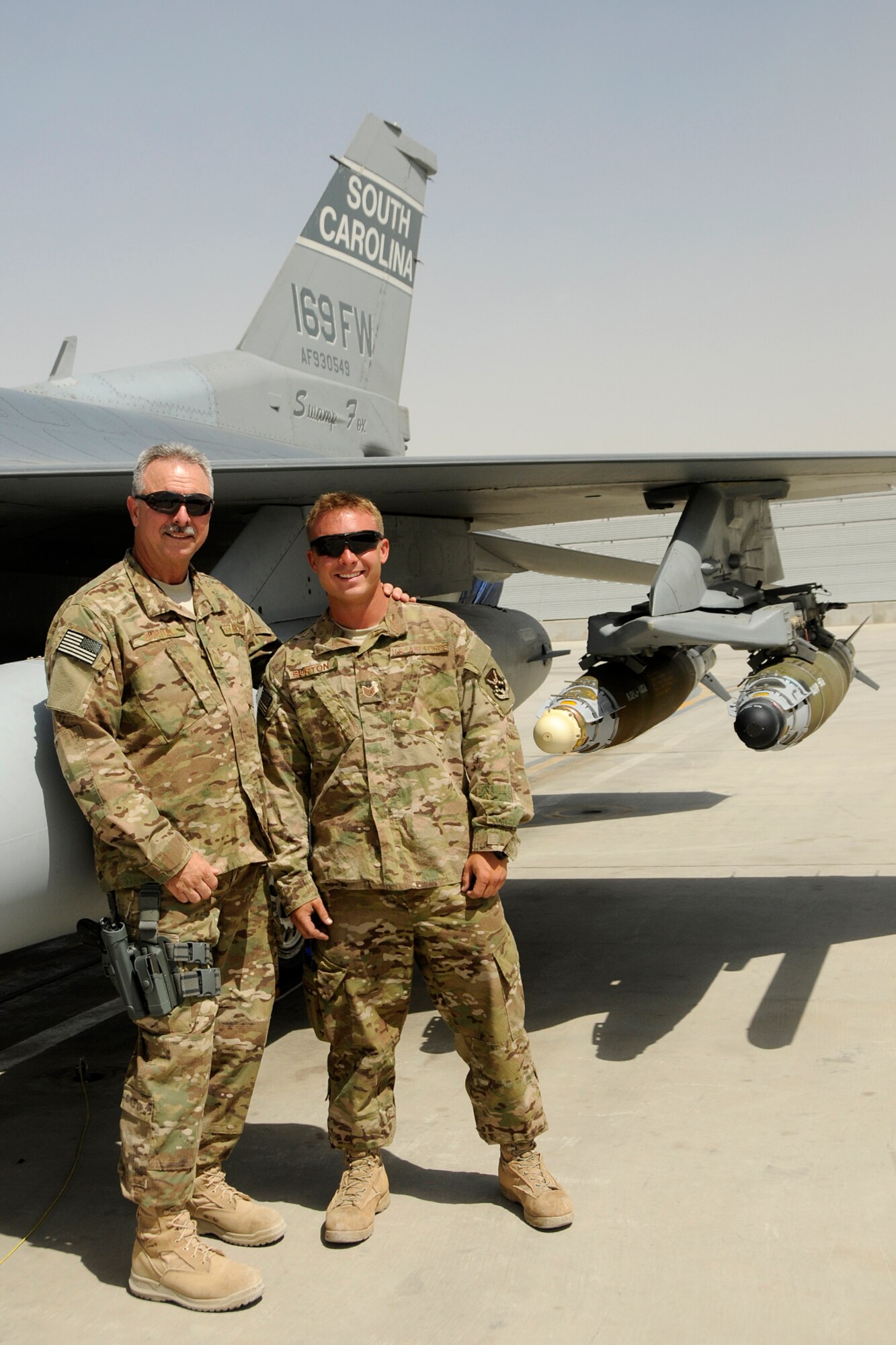 Chief Master Sgt. Dennis Burton, maintenance superintendent and his son, Tech. Sgt. Brandon Burton, a crew chief assigned to the 451st Expeditionary Aircraft Maintenance Squadron at Kandahar Airfield, Afghanistan, pose for a photo on the flight line by an F-16 Fighting Falcon June 13, 2012. Personnel are deployed from McEntire Joint National Guard Base, S.C., in support of Operation Enduring Freedom. Swamp Fox F-16's, pilots, and support personnel began their Air Expeditionary Force deployment early April to take over flying missions for the air tasking order and provide close air support for troops on the ground in Afghanistan.     
(U.S. Air Force photo/TSgt. Caycee Cook)
