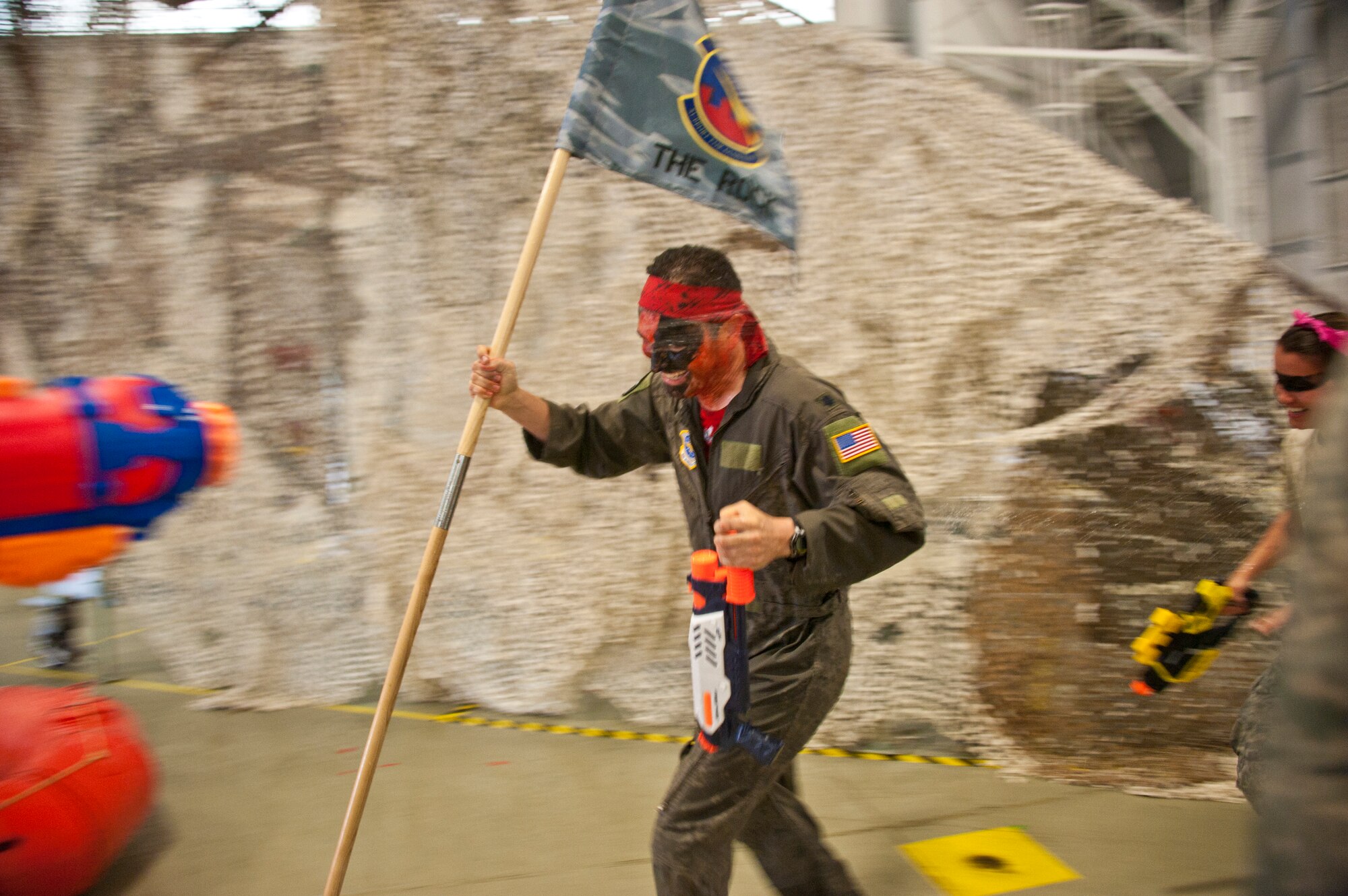 Lt. Col. Brent Mesquit, 2nd Air Refueling Squadron commander, runs with the 305th Operations Support Squadron guidon during the 305th Operations Group Combat Dining In at Hangar 23 June 8. About 120 members of the 305th OG attended the event. The unit intends to hold the event annually. (U.S. Air Force photo by Staff Sgt. David Carbajal/Released)