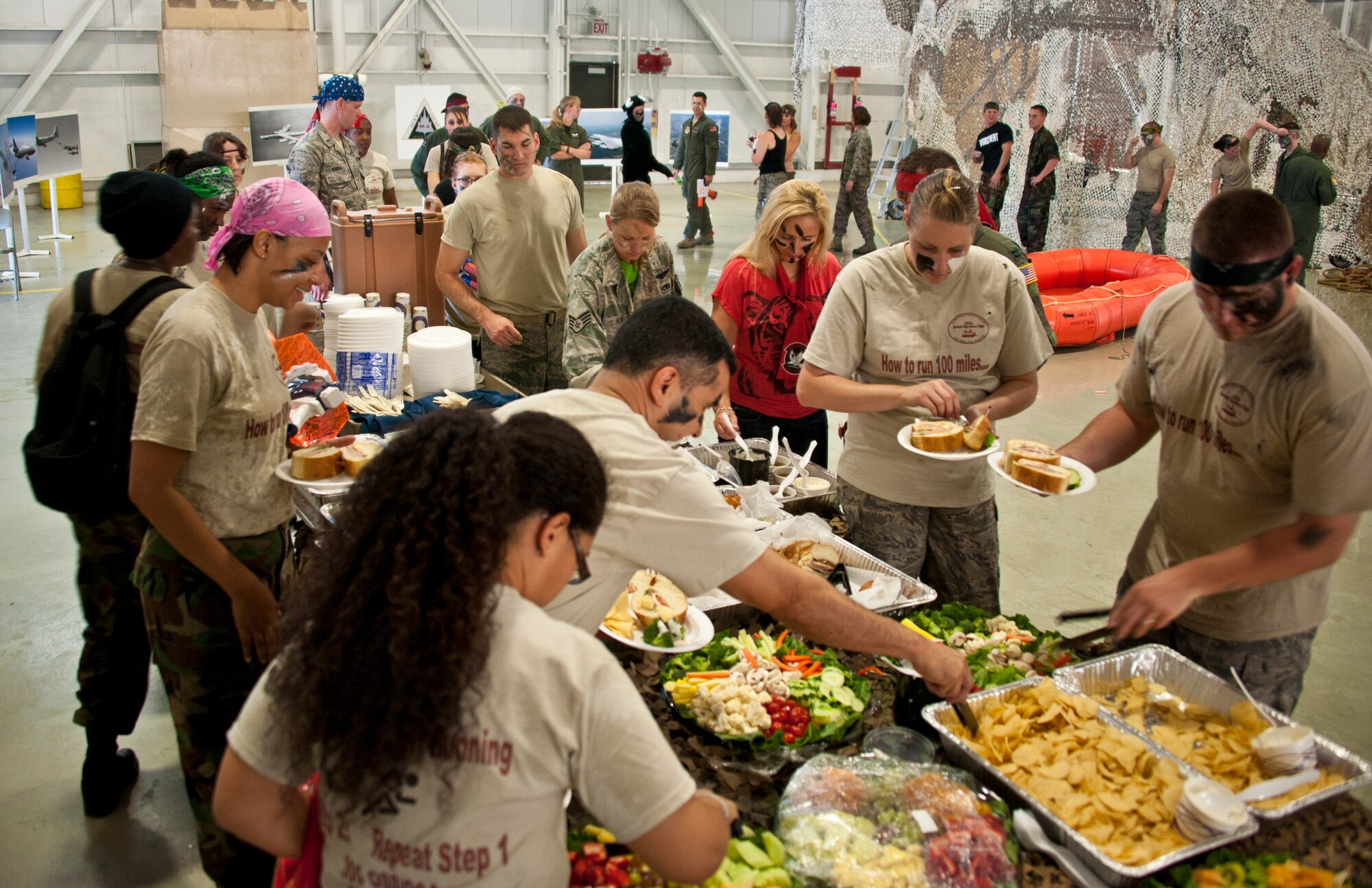 Members of the 305th Operations Group walk through the food line during the 305th OG combat dining in at Hangar 23 June 8. Members of the 6th Airlift Squadron, 2nd and 32nd Air Refueling squadrons and the 305th Operations Support Squadron participated in this year's event. (U.S. Air Force photo by Staff Sgt. David Carbajal/Released)