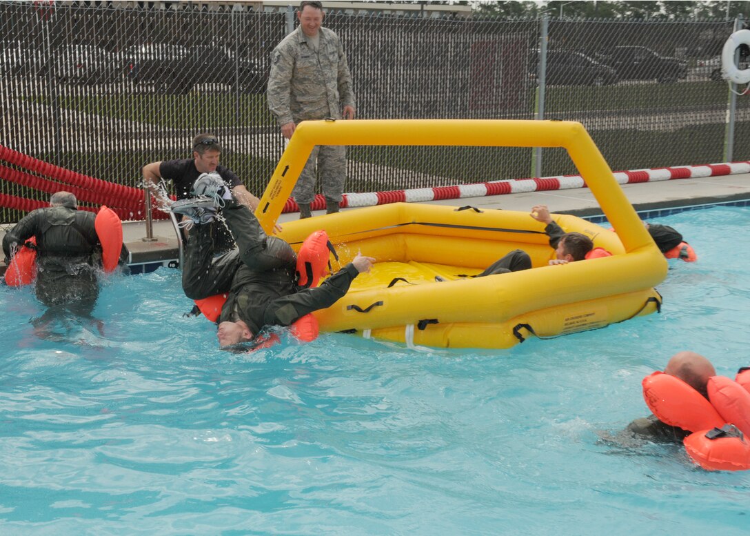 Lt. Col. Timothy Howell exits the nine man life raft used during Water Survival Skills Training June 12, 2012 at the Combat Readiness Training Center.  The training was used as an annual refresher course on water survival skills. (U.S photo by Senior Airman Jessica Fielder)