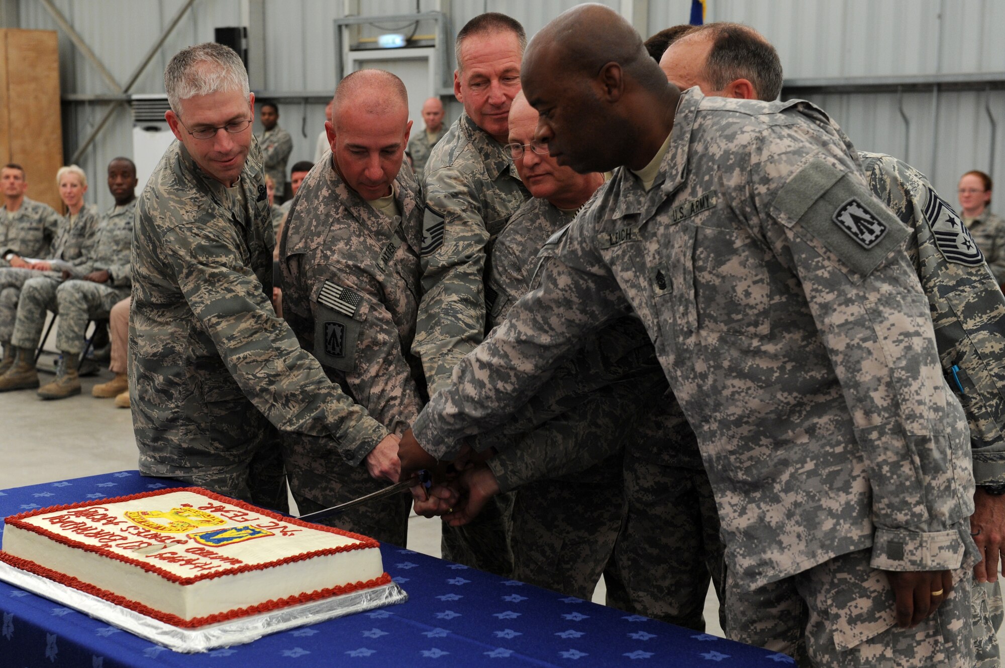 SOUTHWEST ASIA - Leadership from the 1st Battalion, 7th Air Defense Artillery Regiment and 380th Air Expeditionary Wing, along with the oldest and youngest soldier and Airman, cut the U.S. Army birthday cake during a patching ceremony at the 380th Air Expeditionary Wing June 14, 2012. The unit, deployed from Ft. Bragg N.C., conducted its patching ceremony in conjunction with the U.S. Army's 237th birthday.  (U.S. Air Force photo/Master Sgt. Scott MacKay)