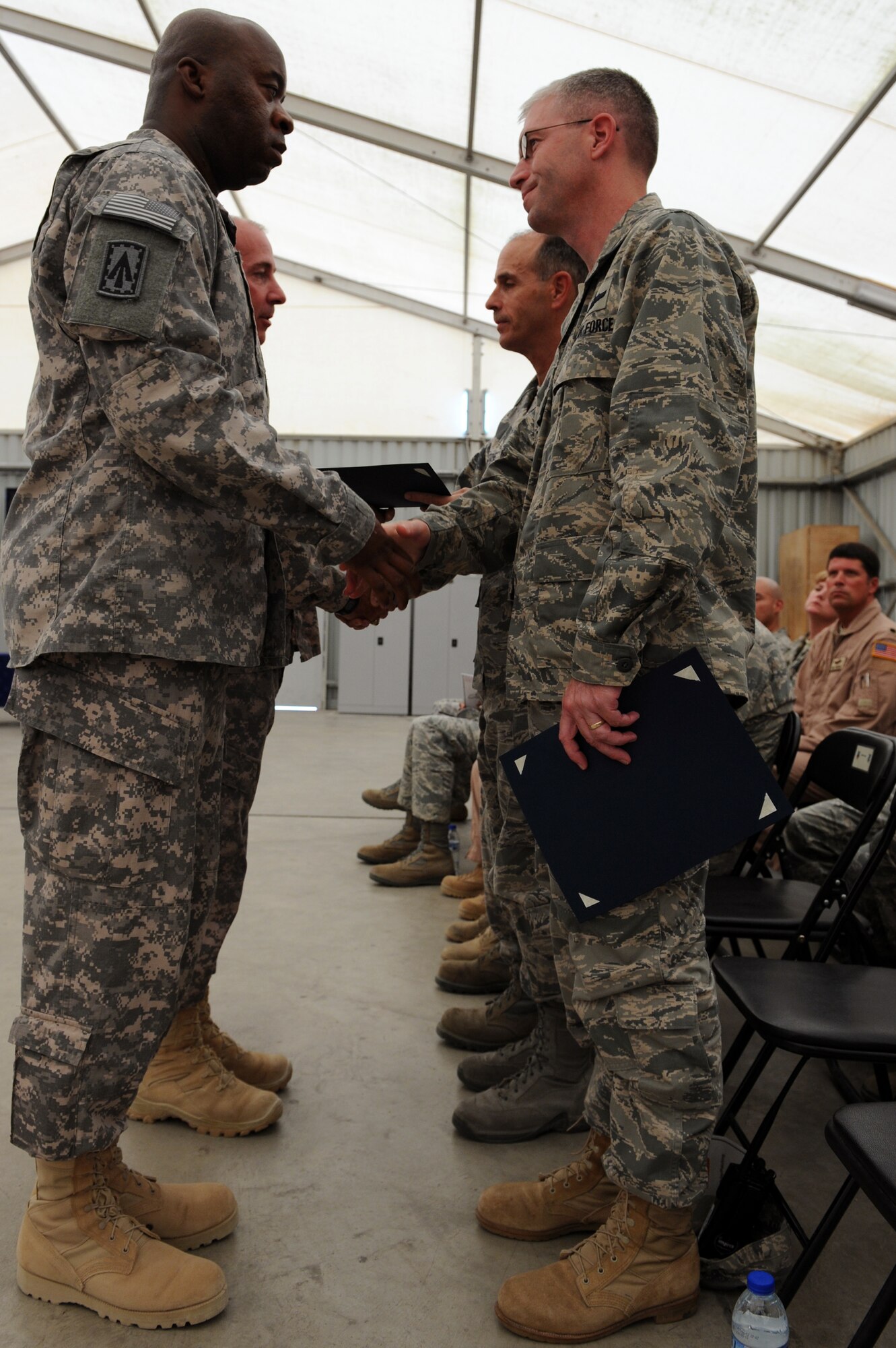 SOUTHWEST ASIA - Sgt. Maj. Micheal Leach, 1st Battalion, 7th Air Defense Artillery Regiment command sergeant major, shakes hands with 380th Air Expeditionary Wing Vice Commander Joel Jackson during the U.S. Army patching ceremony June 14, 2012. The unit, deployed from Ft. Bragg N.C., conducted its patching ceremony in conjunction with the U.S. Army's 237th birthday.  (U.S. Air Force photo/Master Sgt. Scott MacKay)