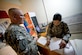 Senior Airman Deborah Vives with the Office of Security Cooperation - Iraq Financial Management team, assists a customer June 6 in Taji, Iraq. The OSC - I FM team travels to several sites in Iraq helping U.S. military personnel and civilian contractors with EagleCash and cash operations, setting up a new way to conduct financial services after the 2011 Armed Forces drawn down.  (U.S. Air Force photo by Staff Sgt. Greg C. Biondo)