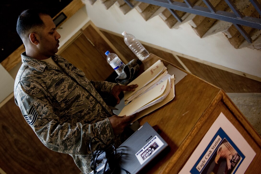 Tech. Sgt. Ivan Prakash with the Office of Security Cooperation - Iraq Financial Management team, sets up a work station June 6 in Taji, Iraq. The OSC - I FM team travels to several sites in Iraq helping U.S. military personnel and civilian contractors with EagleCash and cash operations, setting up a new way to conduct financial services after the 2011 Armed Forces drawn down.  (U.S. Air Force photo by Staff Sgt. Greg C. Biondo)

