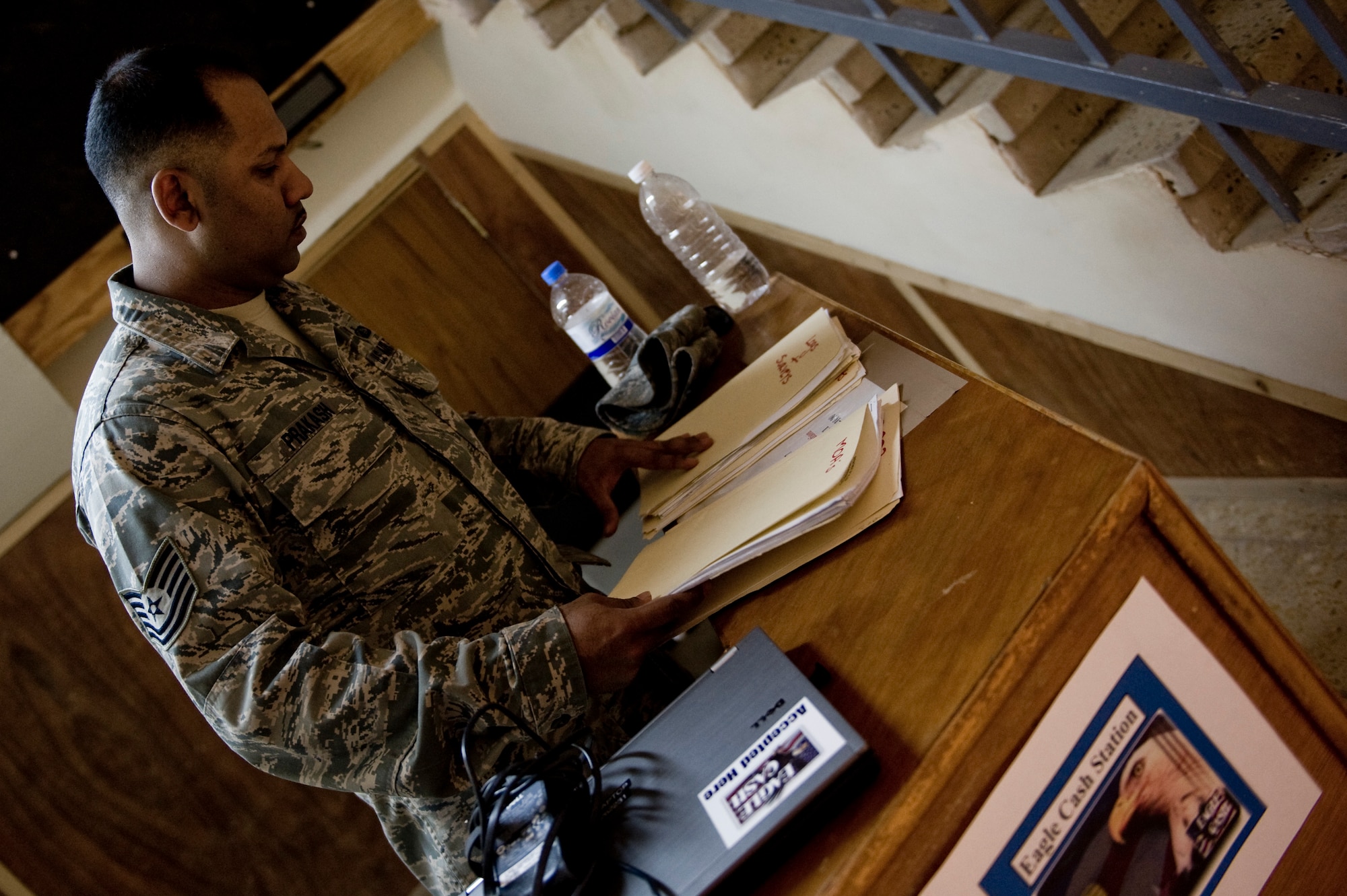 Tech. Sgt. Ivan Prakash with the Office of Security Cooperation - Iraq Financial Management team, sets up a work station June 6 in Taji, Iraq. The OSC - I FM team travels to several sites in Iraq helping U.S. military personnel and civilian contractors with EagleCash and cash operations, setting up a new way to conduct financial services after the 2011 Armed Forces drawn down.  (U.S. Air Force photo by Staff Sgt. Greg C. Biondo)


