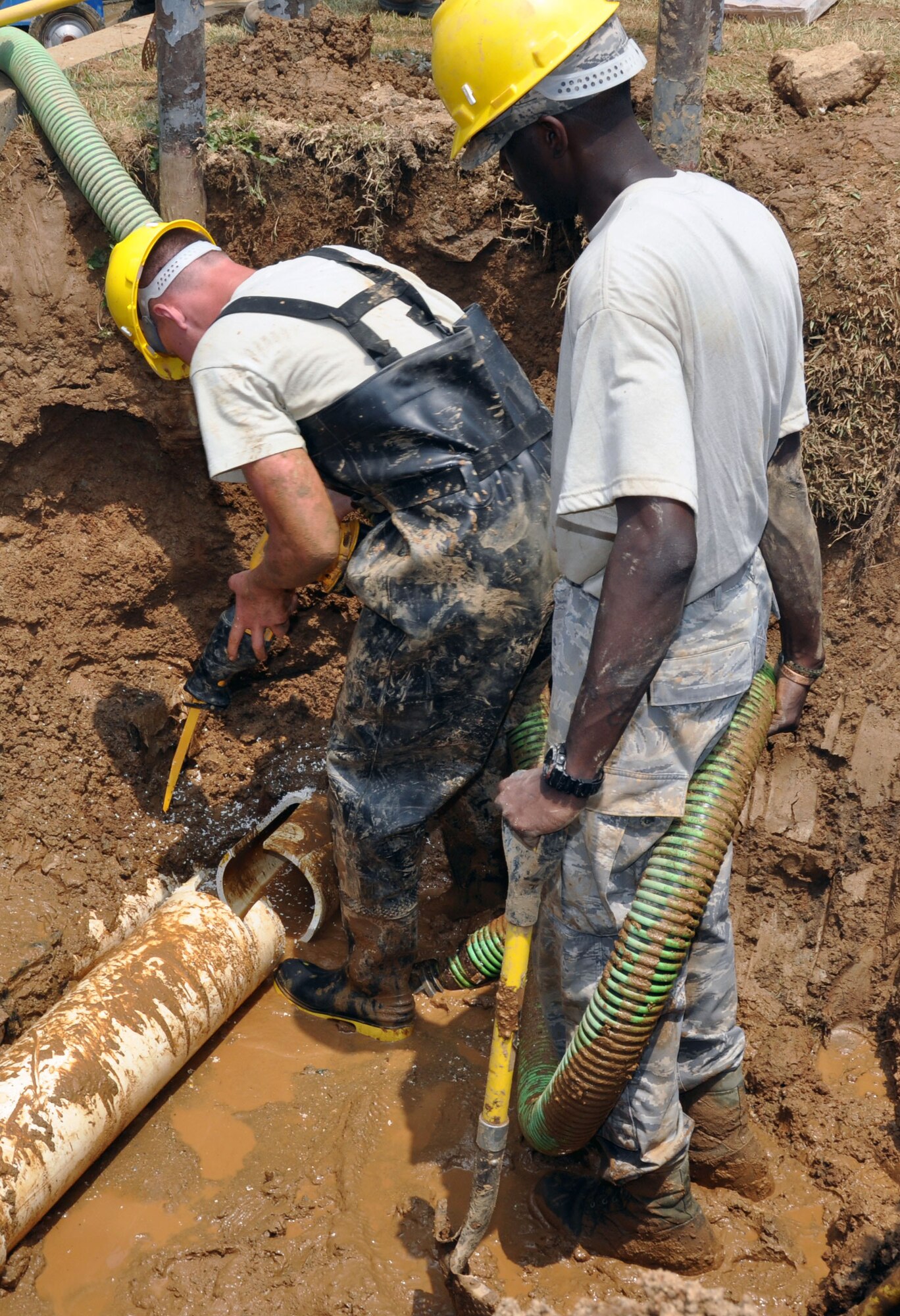 Senior Airman Kenneth Small III and Airman 1st Class Jacob Stratton, 51st Civil Engineer Squadron water and fuel maintainers, cut into a damaged water pipe to make room for a replacement at Osan Air Base, Republic of Korea, June 14, 2012. Water and fuel maintainers ensure the water supply to dorms, offices and housing at Osan remains in good working order. (U.S. Air Force photo/Senior Airman Michael Battles)