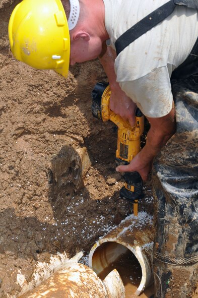 Airman 1st Class Jacob Stratton, 51st Civil Engineer Squadron water and fuel maintainer, cuts into a damaged water pipe to make room for a replacement June 14, 2012, at Osan Air Base, Republic of Korea. Water and fuel maintainers ensure the water supply to dorms, offices and housing at Osan remains in good working order. (U.S. Air Force photo/Senior Airman Michael Battles)