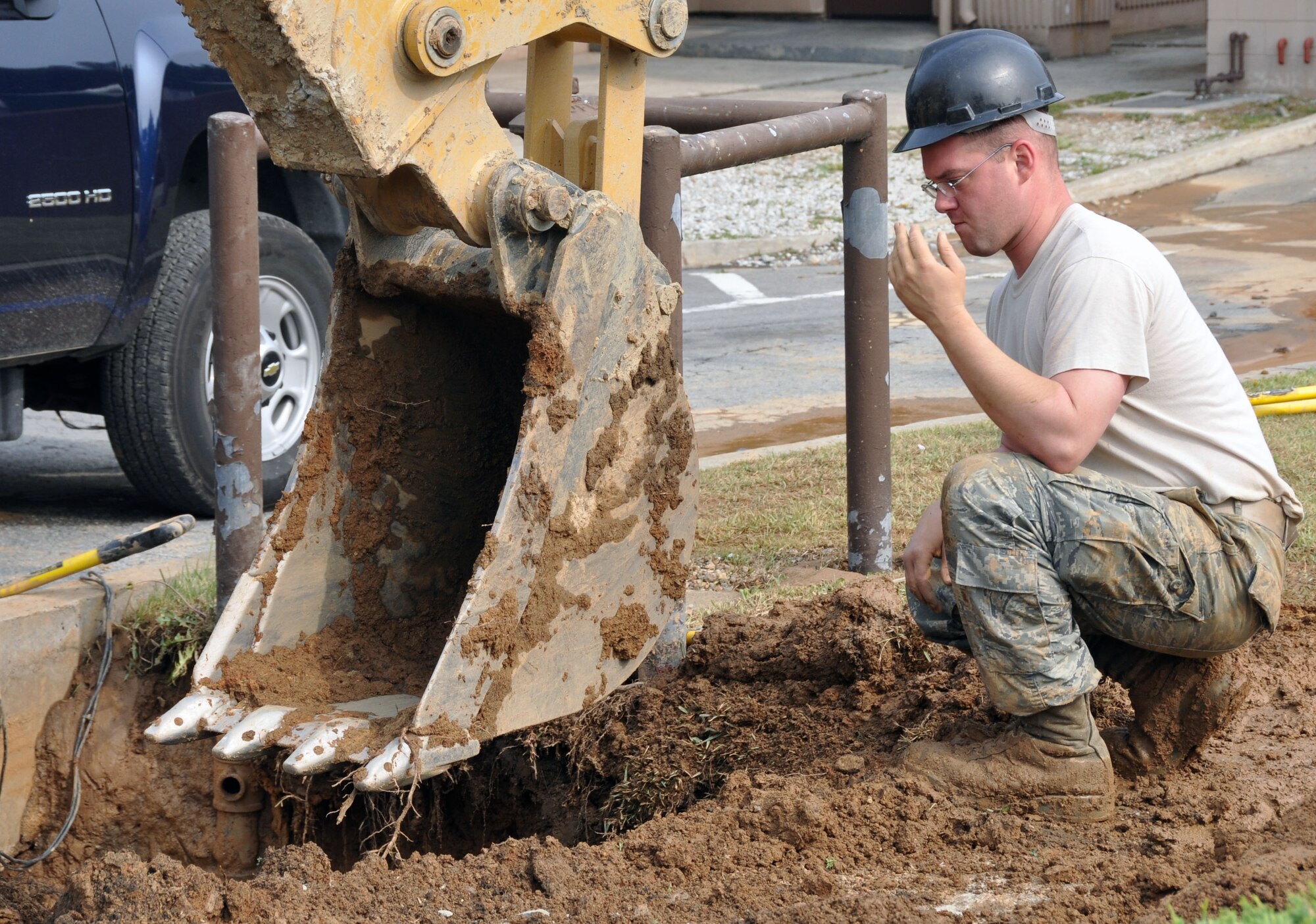 Staff Sgt. George Graybill, 51st Civil Engineer Squadron water and fuel maintainer, guides a backhoe into position to dig for a damaged water pipe at Osan Air Base, Republic of Korea, June 14, 2012. Water and fuel maintainers ensure the water supply to dorms, offices and housing at Osan remains in good working order. (U.S. Air Force photo/Senior Airman Michael Battles)