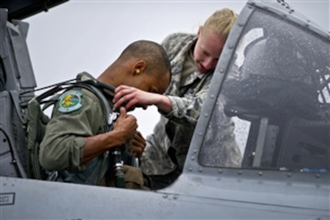U.S. Air Force Airman 1st Class Sarah Sagers helps U.S. Air Force Capt. James Flagg get strapped into an A-10 Thunderbolt II before departing for a combat training mission during Red Flag-Alaska 12-2 on Eielson Air Force Base, Alaska, June 12, 2012. Sagers, a crew chief, is assigned to the 51st Aircraft Maintenance Squadron and Flagg, a pilot, is assigned to the 25th Fighter Squadron.