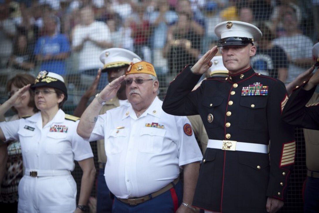 Sgt. Maj. Michael P. Barrett, sargeant major of the Marine Corps, salutes during the national anthem played by the Marine Corps Base Quantico band at the Cleveland Indians game here, June 15, 2012, during Marine Night at Progressive Stadium during Marine Week Cleveland. Outside the stadium, Marine Corps vehicles, aircraft and equipment were available for public viewing at the Gateway Plaza. Public Square, Voinovich Park, and Rock and Roll Hall of Fame are some of other venues that display the equipment as well. Marine Week Cleveland celebrates community, country and the Corps. More than 750 Marines journeyed to Cleveland for the event. Ohio has more than 9,000 active and reserve Marines, making it one of the top-five producers of Marines. The culminating event for the week is the Marine Air-Ground Task Force demo, June 16-17, in which Marines will invade the Burke Lakefront Airport by land, air, and sea. (U.S. Marine Corps Photo by Cpl. Marcin Platek)::r::::n::