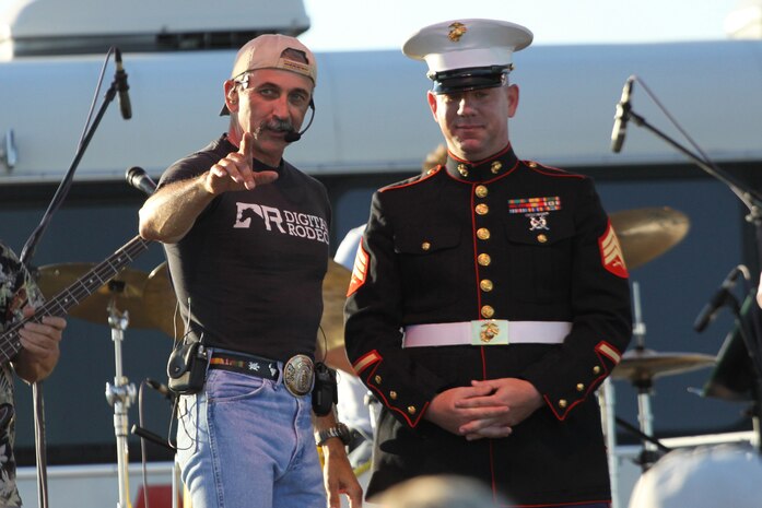 Country singer Aaron Tippin brings Sgt. David Harper onstage during the concert portion of the 2nd Annual Ray Fagen Memorial Airshow June 16. Tippin presented Harper with a bicycle, which will be donated to the Toys for Tots Foundation. Harper is a recruiter out of the Sioux Falls, S.D., office.