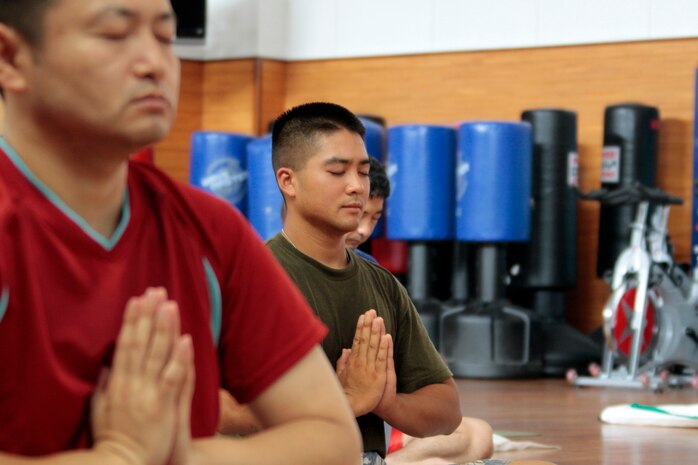 Zachary Nguyen, Zen for Men yoga class participant, performs a pose during the Zen for Men hatha style yoga class, which took place inside the IronWorks Gym aerobics room here June 16,2012. The origina of hatha yoga are traced back to 11th century Buddhist text.