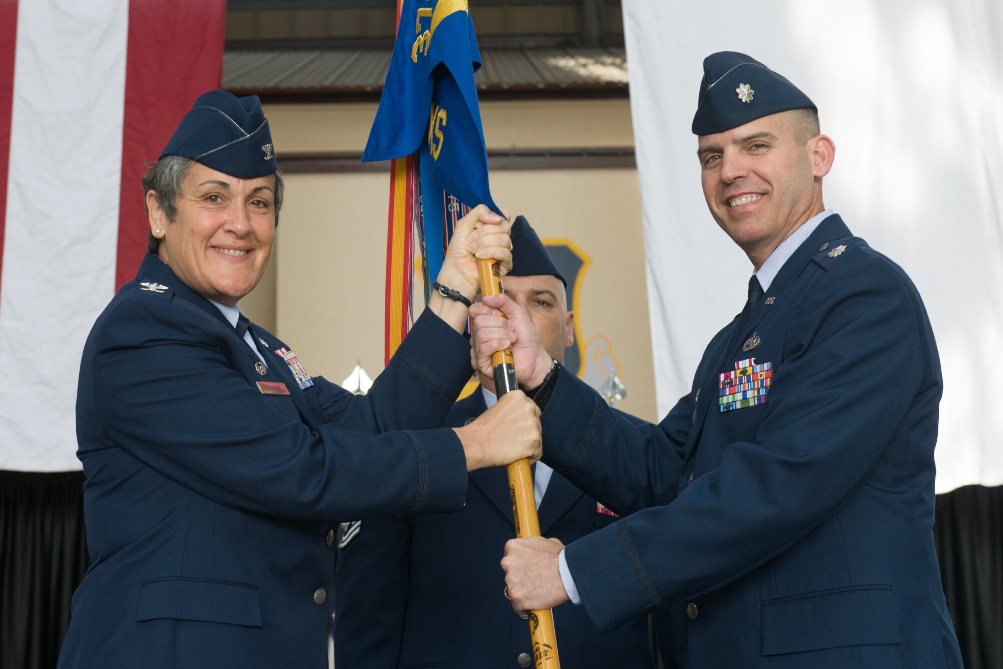 YOKOTA AIR BASE, Japan -- Col. Darlene Sanders, 374th Maintenance Group commander, left, passes the guidon to Lt. Col. William Phillips, incoming 374th Maintenance Squadron commander, right, during the 374th Maintenance Squadron change of command ceremony at Yokota Air Base, Japan, on June 15, 2012. Phillips was the Chief of Logistics for the 13th Air Force, Detachment 1 at Yokota Air Base, Japan. (U.S. Air Force photo by Osakabe Yasuo)