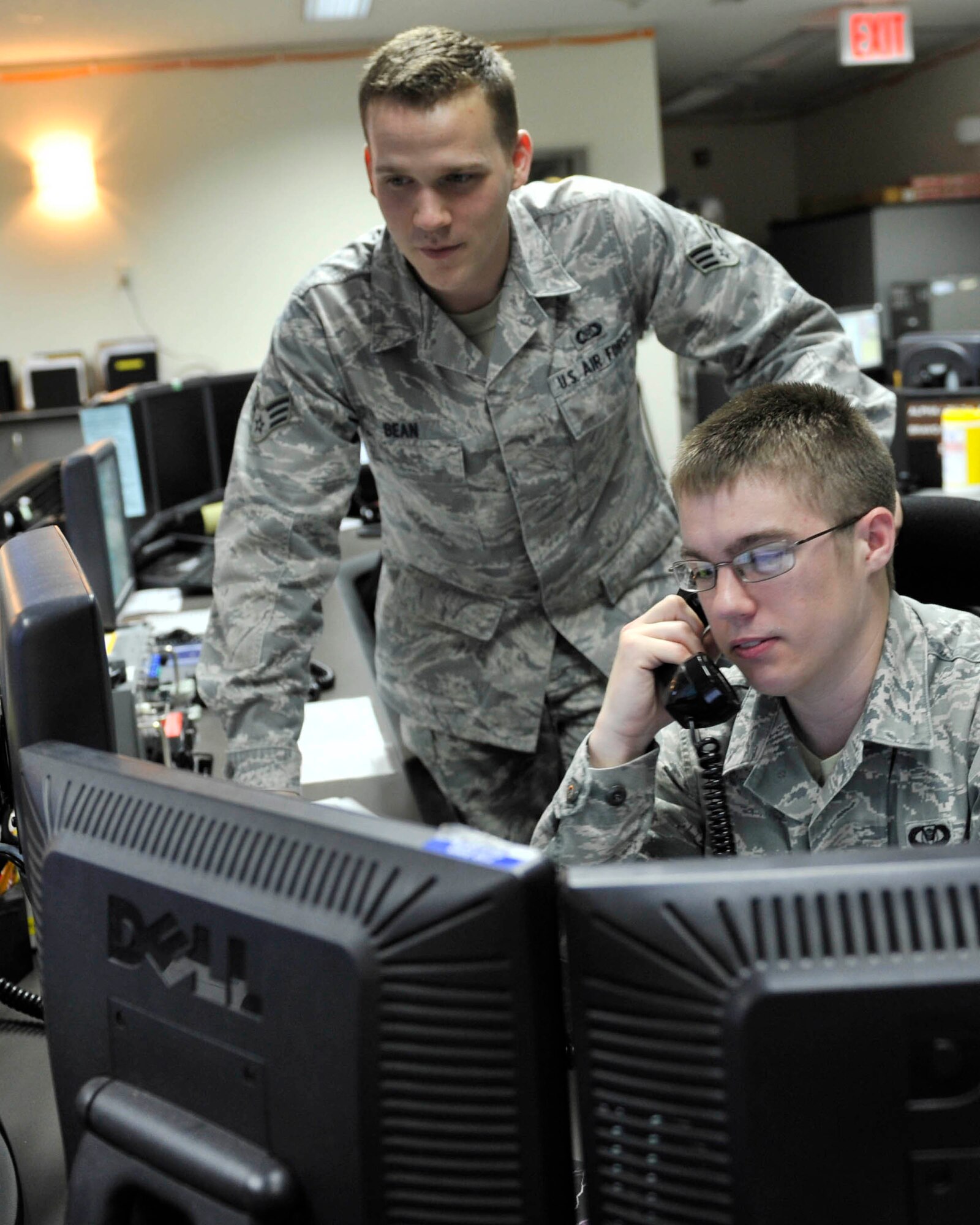 YOKOTA AIR BASE, Japan -- Senior Airman Mathew Bean, left, and Airman 1st Class Anders, 730th Air Mobility Squadron airlift operations controllers respond to a flightline notification inside the Air Mobility Command Center, at Yokota Air Base, Japan, May 8, 2012. The command center is a 24-hour operations hub that is responsible for ensuring aircraft and cargo movements run smoothly while also reporting any issues that may affect inbound and outbound missions.  (U.S. Air Force photo by Senior Andrea Salazar)