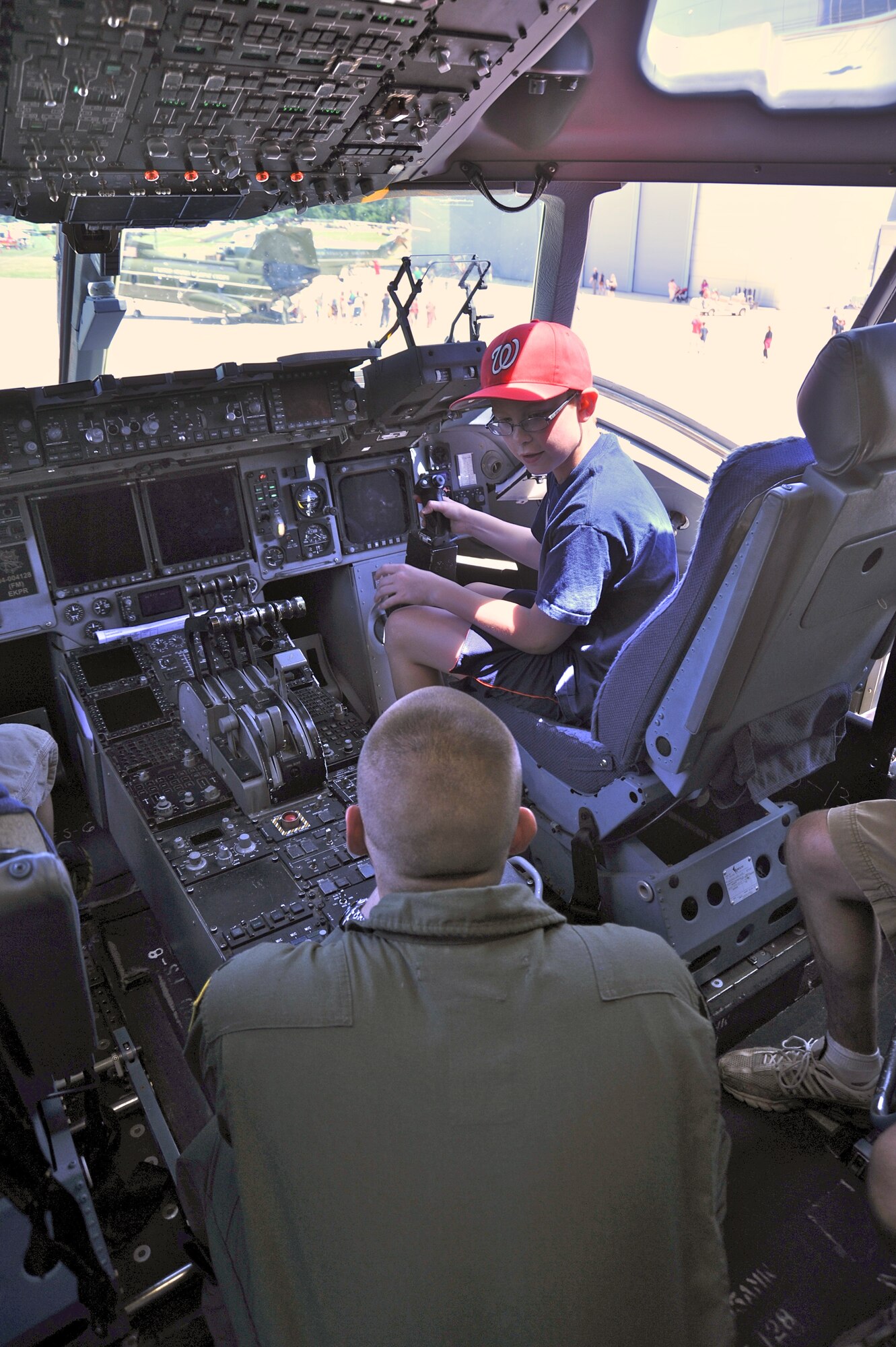 1st Lt. David Bishop, a pilot with the 305th Air Mobility Wing, answers questions about the controls of a C-17 Globemaster to Nicholas Kendall, 10, at "Become a Pilot Day" near Chantilly, Va., June 16, 2012. Become a Pilot Day is an annual event at the National Air and Space Museum, intended to introduce children to careers in aviation. (U.S. Air Force photo/Airman 1st Class Alexander W. Riedel)