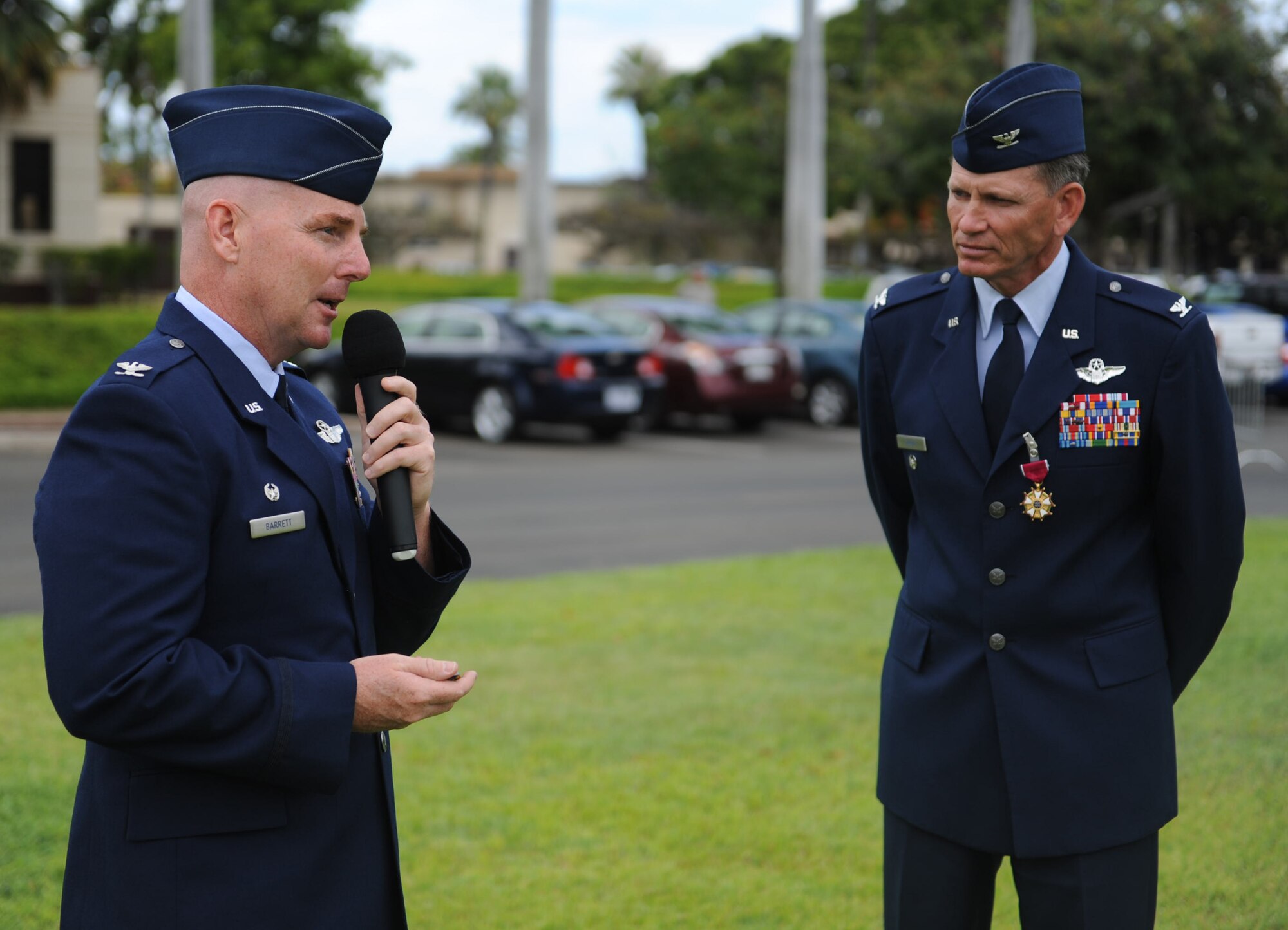Col. Joe Dague, 15th Wing vice commander (right), listens as Col. Sam Barrett, 15th WG commander, speaks to Airmen from the 15th WG during Dague's Legion of Merit presentation ceremony June 15 at Joint Base Pearl Harbor-Hickam, Hawaii. The Legion of Merit decoration is presented to officers and enlisted men of the Armed Forces of the United States and on nationals of other counties who have distinguished themselves by exceptionally meritorious conduct in the performance of outstanding services and achievements.