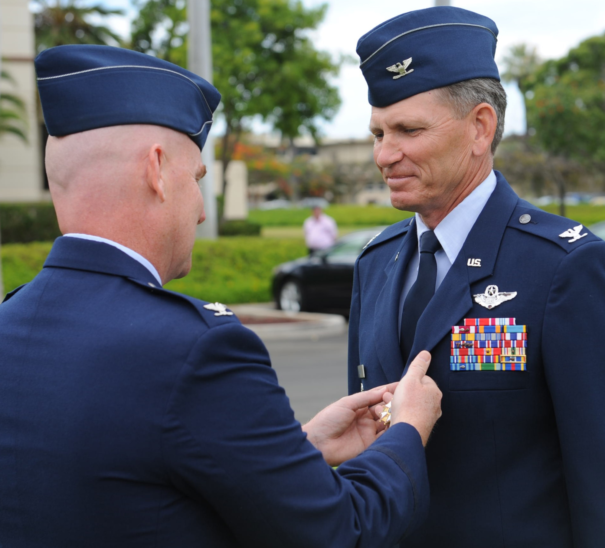 Col. Sam Barrett, 15th Wing commander, presents the Legion of Merit decoration to Col. Joe Dague, 15th WG vice commander, during a ceremony June 15 at Joint Base Pearl Harbor-Hickam, Hawaii. The Legion of Merit decoration is presented to officers and enlisted men of the Armed Forces of the United States and on nationals of other counties who have distinguished themselves by exceptionally meritorious conduct in the performance of outstanding services and achievements.