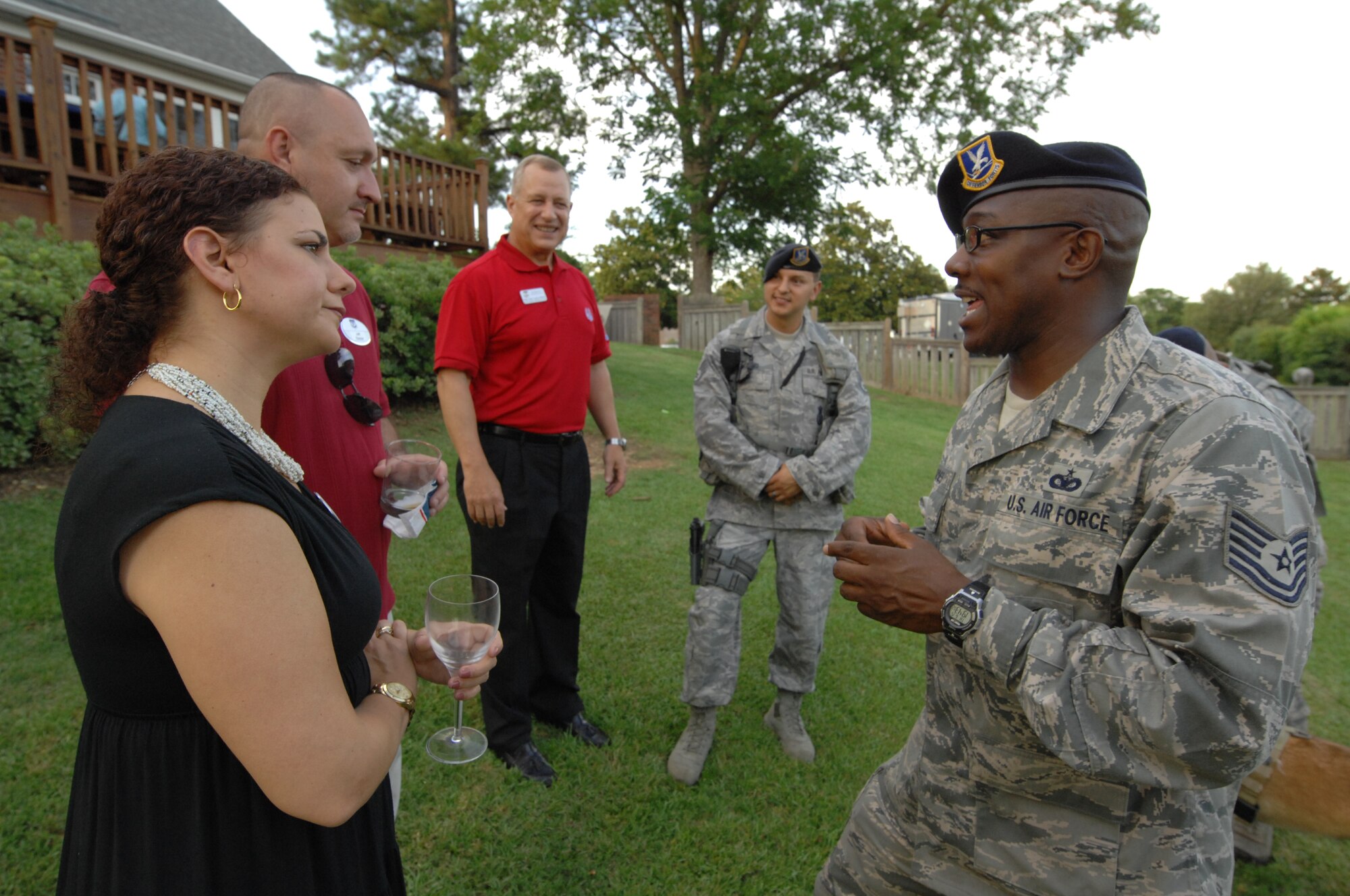 SHAW AIR FORCE BASE, S.C. - U.S. Air Force Tech. Sgt. Jemal Jones, a native of Jacksonville, N.C. and the military working dog kennel master for the 20th Security Forces Squadron, Shaw Air Force Base, S.C. answers a few questions from Lisa Baxter, a senior sales manager for the Hilton Americas and the current secretary for the Young Professionals of Sumter after watching demonstrations from an explosive ordnance disposal team and a military working dog team while at the home of 9th Air Force Commander, Maj. Gen. Lawrence L. Wells June 14, 2012. The demonstration was an opportunity for members of the YPS and Shaw’s company grade officers to meet and establish new relationships between one another.  (U.S.  Air Force photo by Master Sgt. Cohen A. Young/Released)