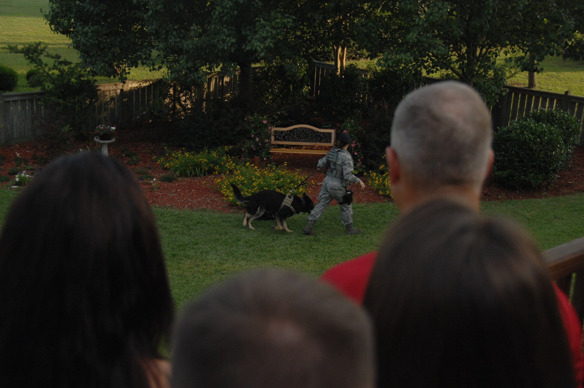 SHAW AIR FORCE BASE, S.C. - Members of the Young Professionals of Sumter and company grade officers of Shaw Air Force Base, S.C. watch the demonstration of a military working dog team while at the home of 9th Air Force Commander, Maj. Gen. Lawrence L. Wells June 14, 2012 for dinner and an opportunity establish new relationships between one other.  (U.S.  Air Force photo by  Master Sgt. Cohen A. Young/Released)