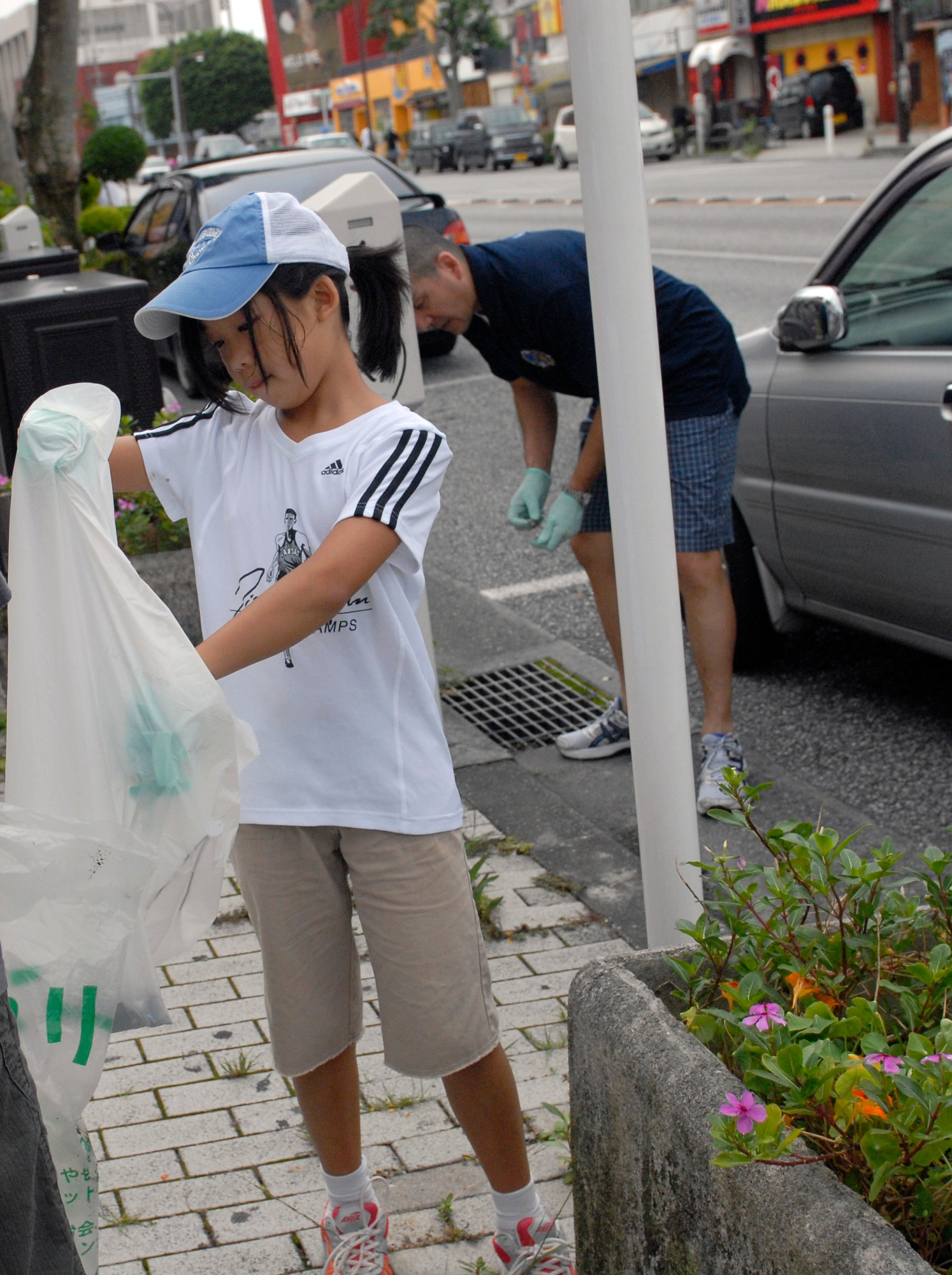 Ellie Paik helps clean up trash at a Gate 2 clean up on Kadena Air Base, Japan, June 16, 2012. "Seeing them teach their kids community service warms my heart," said Gen. Molloy. "I see our senior enlisted leaders teaching the next generation what community service means, and I see (that) our future is secure." (U.S. photo by Airman 1st Class Malia Jenkins)